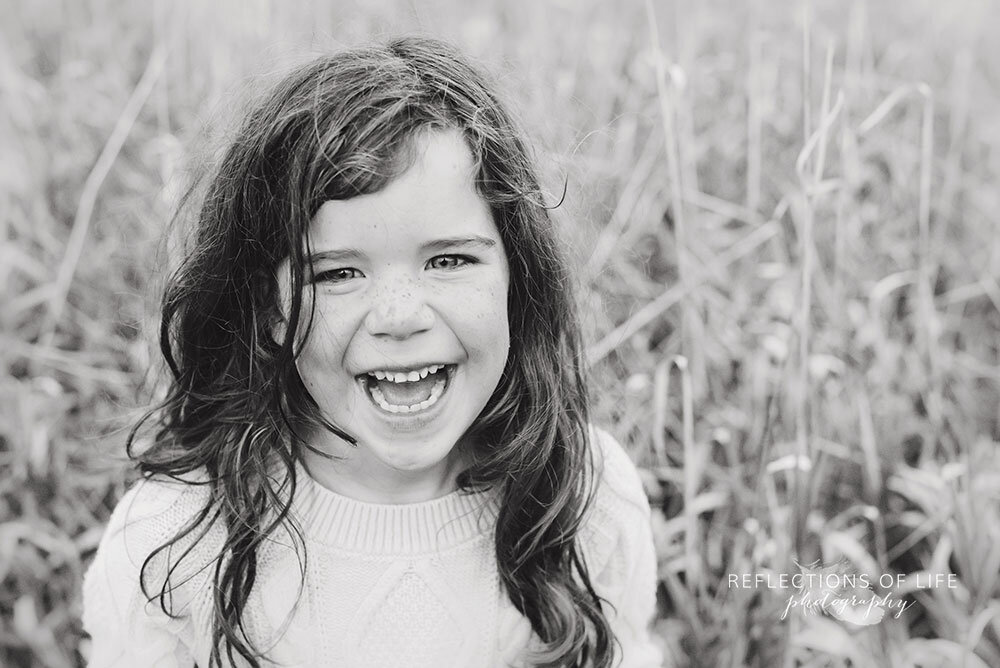 Little girl smiling at the camera in black and white