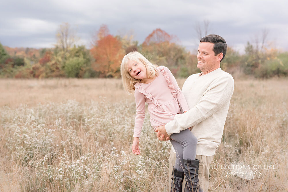 Daddy holding his daughter outdoor photoshoot playtime in Niagara Region Ontario
