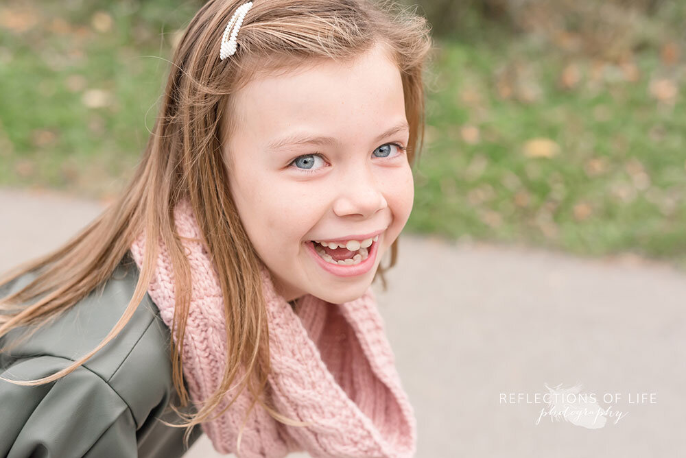 Adorbable little girl in green dress and pink scarf laughing Niagara Photographer