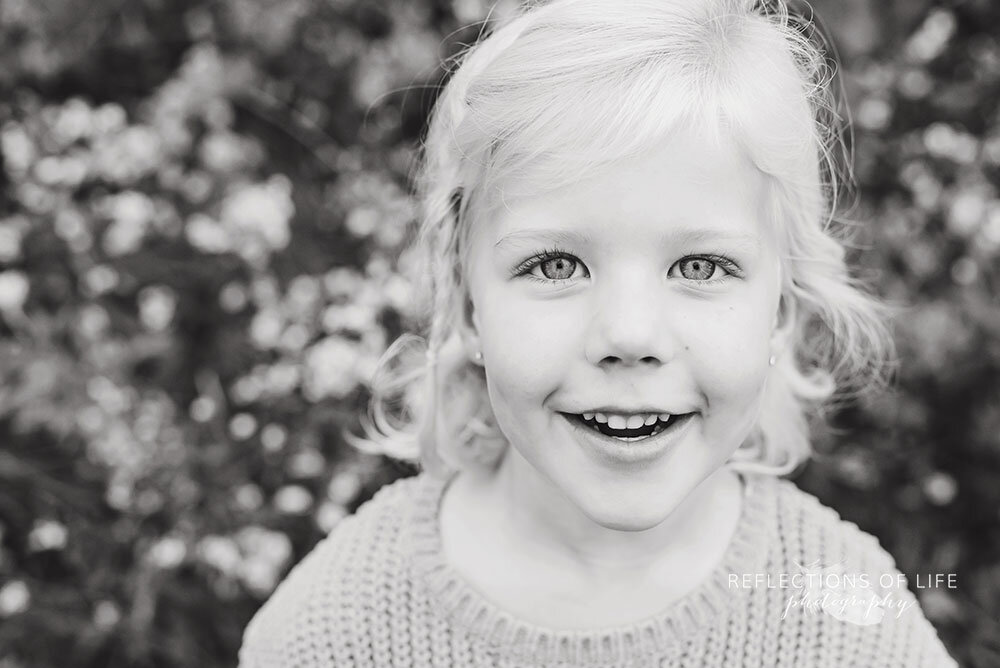 Black and white image of little girl smiling at the camera Niagara Region family photos