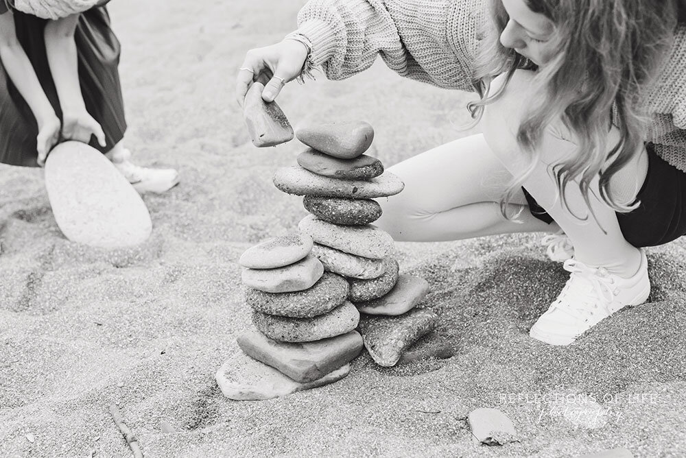 Stacking rocks together at family photoshoot in Casablanca Beach in Grimsby Ontario