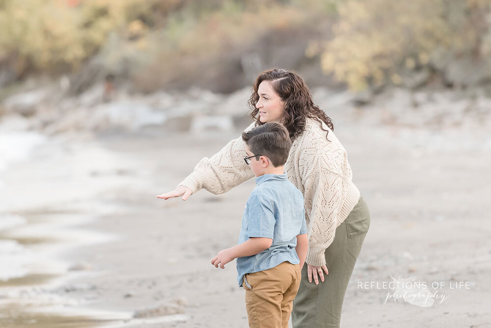 Mom teaches son how to skip rocks during family photoshoot at Casablanca Beach Grimsby Ontario