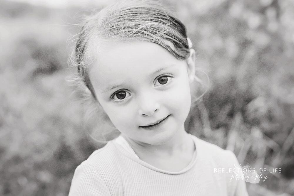 Adorable little girl with large brown eyes in black and white