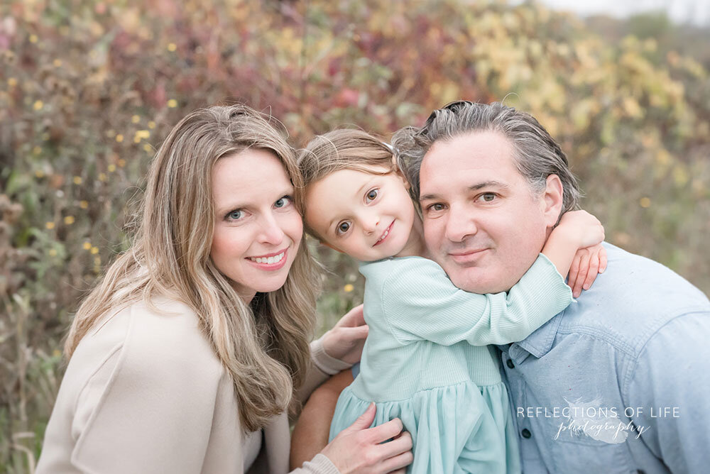 Little girl with her parents in open field Niagara Region family photoshoot