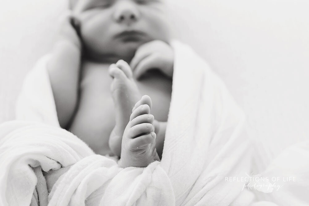 Newborn baby boy toes in black and white