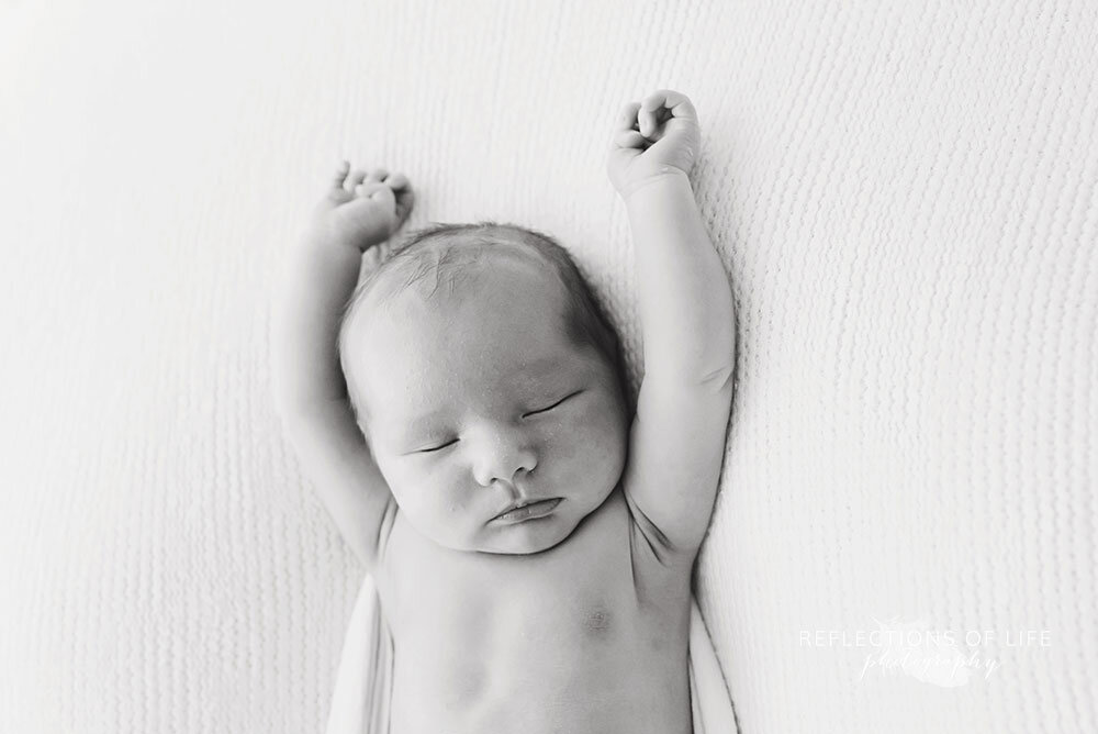 Relaxed baby with hands above his head Niagara Region Professional Photography