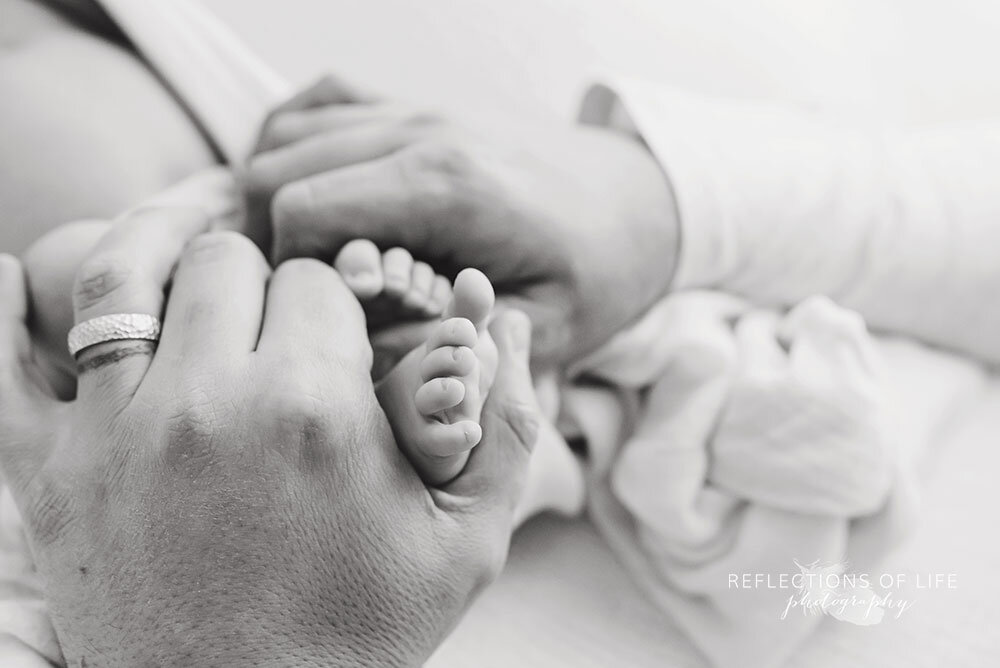 Newborn-baby-toes-in-daddy's-hands-Niagara-Region-newborn-photos