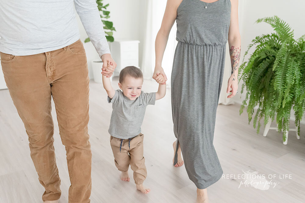 Mom-and-dad-walking-across-the-studio-with-little-boy-Grimsby-family-and-child-photography