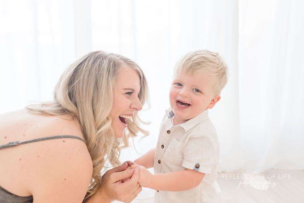 Mom and boy laugh together in family photography studio niagara