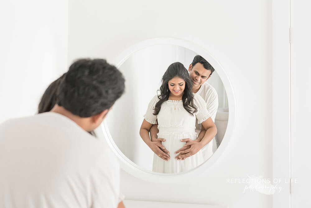 Couple in mirror gazing at baby bump maternity photography niagara