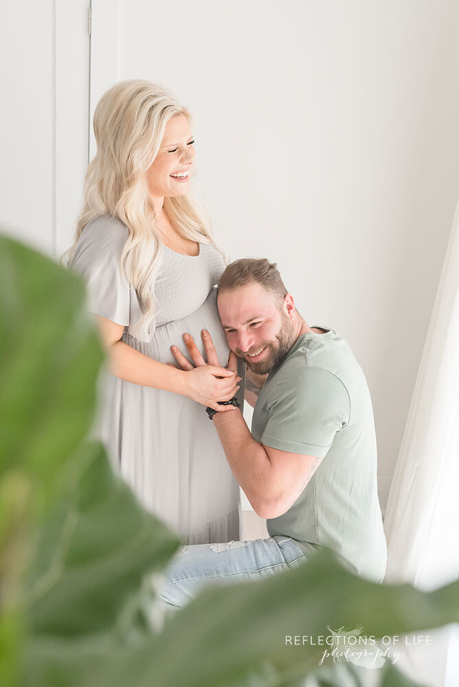 man listens to pregnant belly