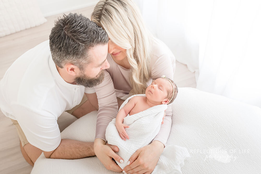 parents huddle over newborn