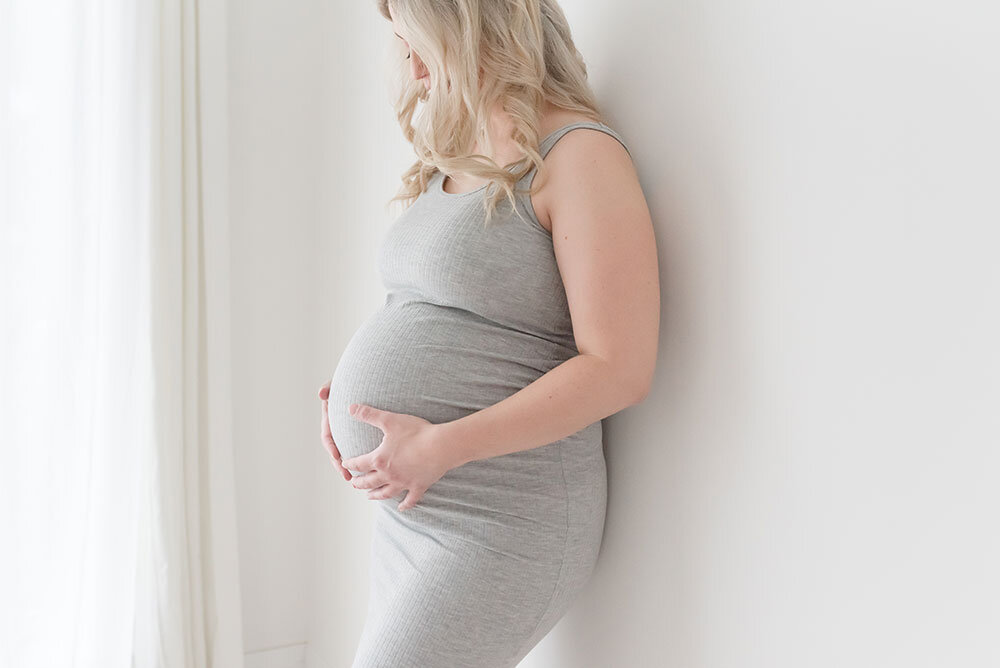 mother holds baby bump