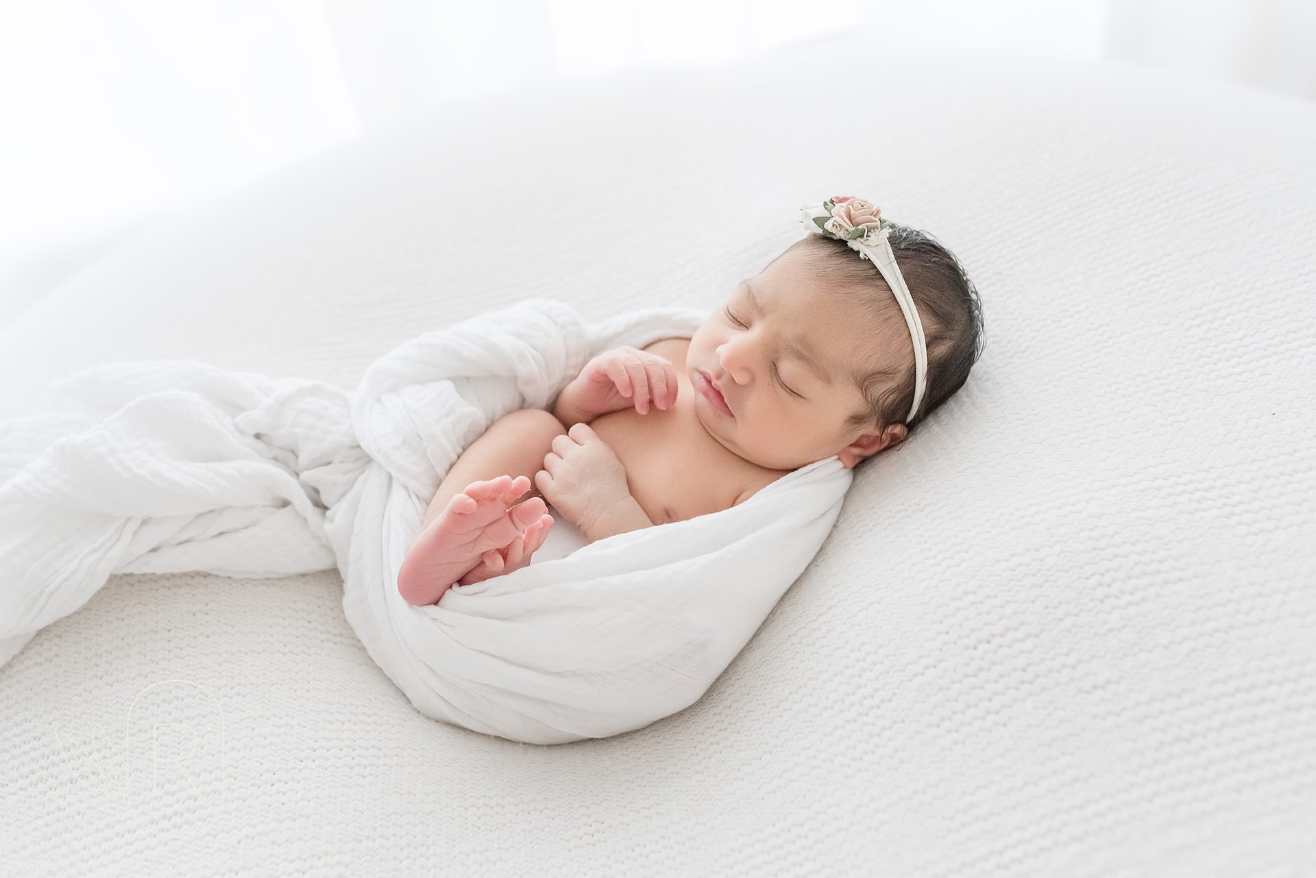 swaddled baby in white muslin
