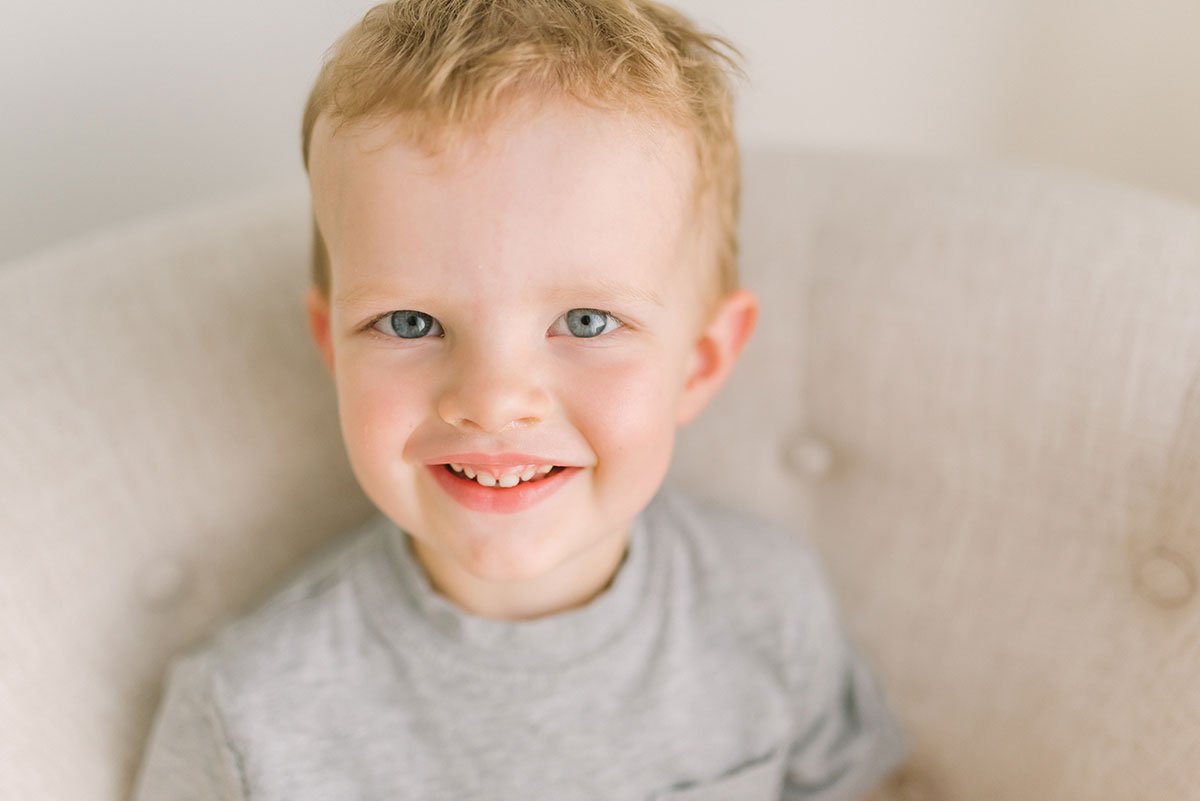 Little boy smiling at camera during family photoshoot in Grimsby Ontario studio