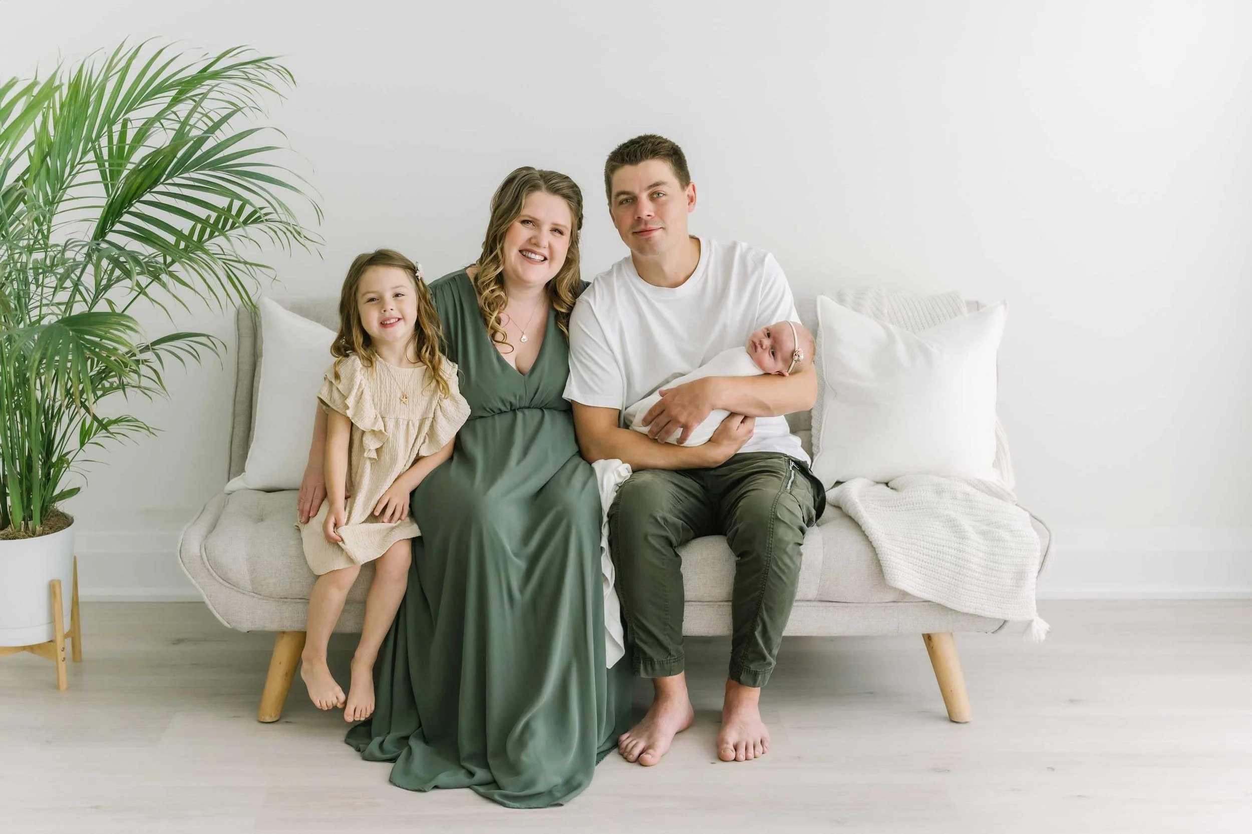 Family holding newborn by Hamilton Newborn Photographer at studio by Reflections