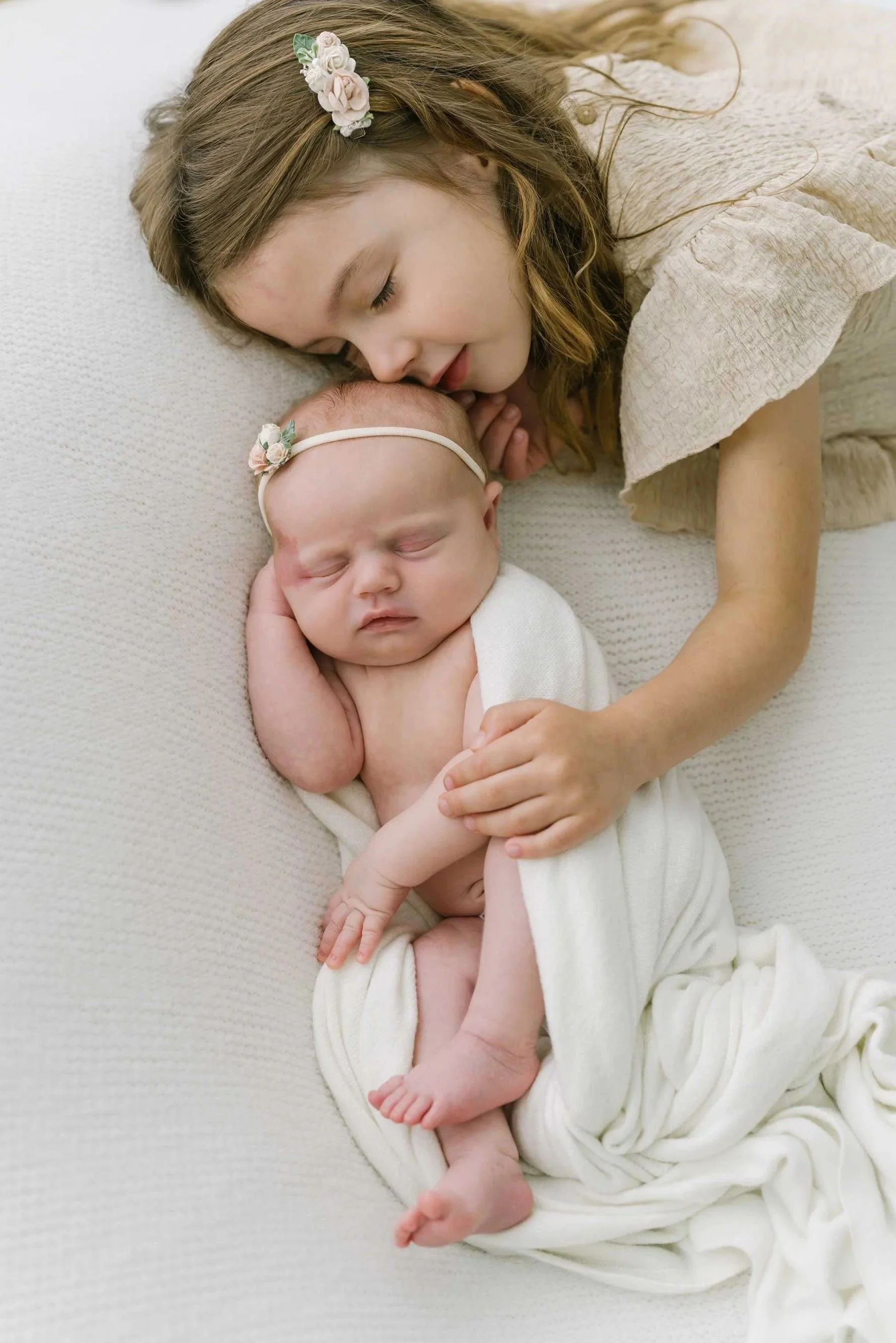 Older sibling and newborn laying down captured by Hamilton Newborn Photographer at studio by Reflections