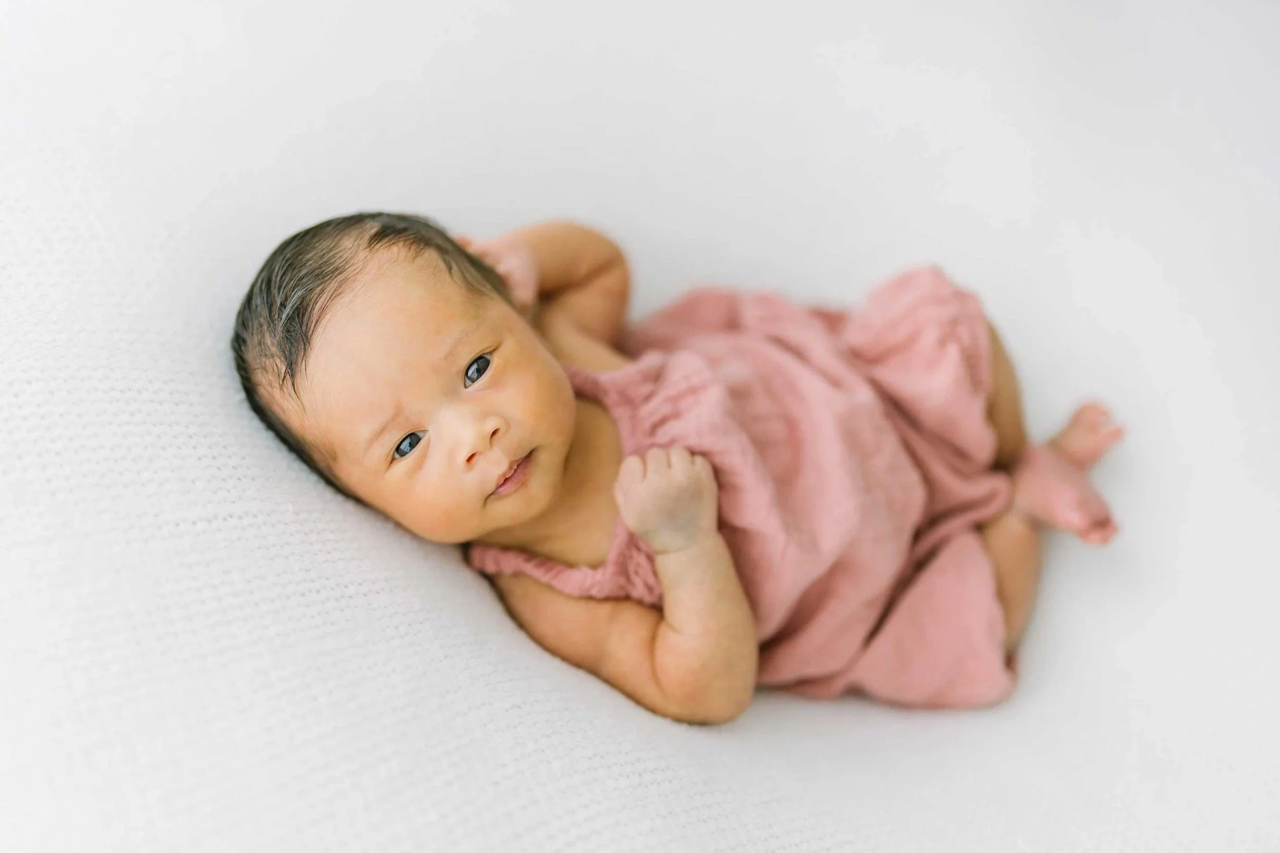 Sleeping baby wearing pink captured by Reflections newborn photography in Hamilton​