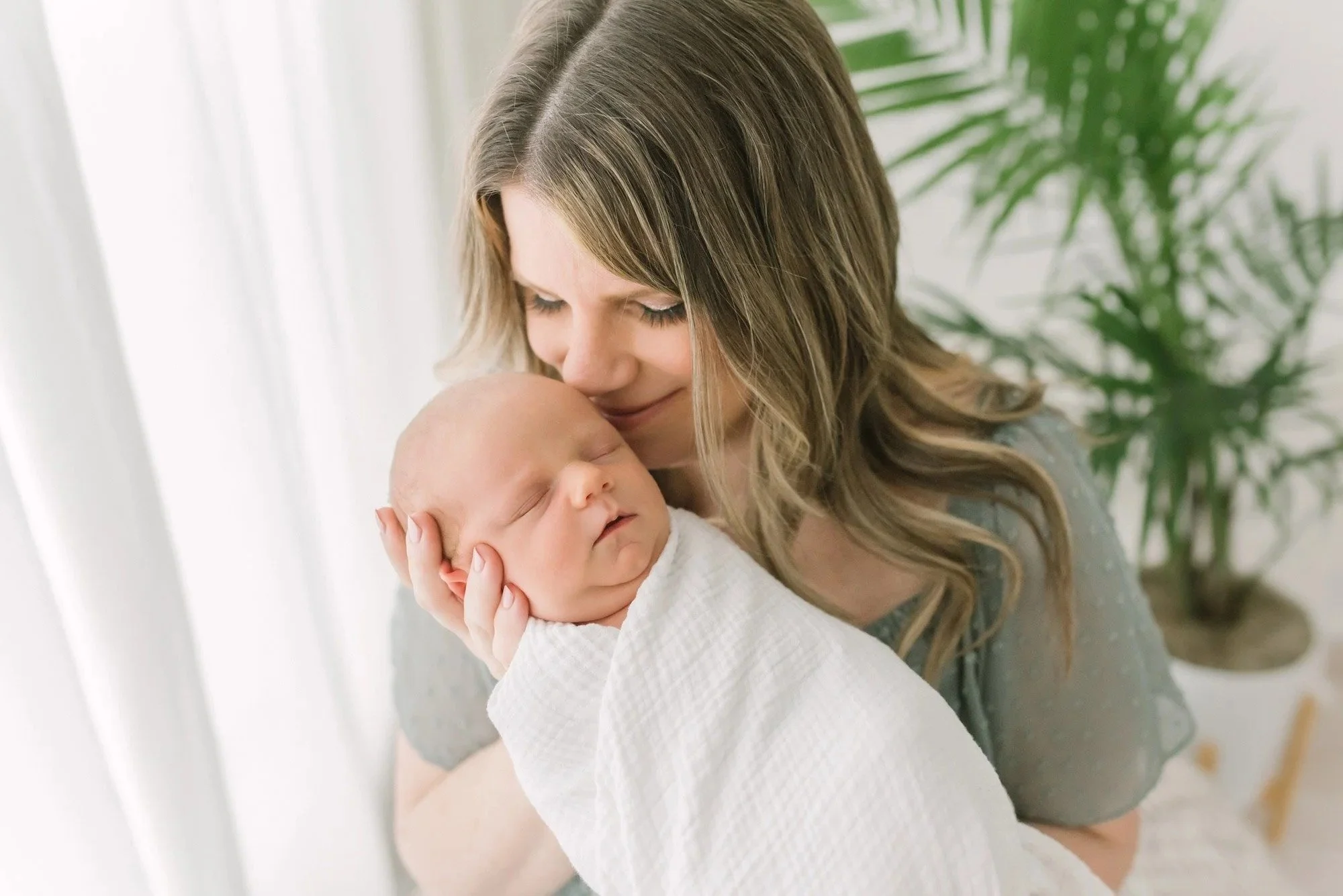 Mom kissing baby in a newborn photography studio in Hamilton. 