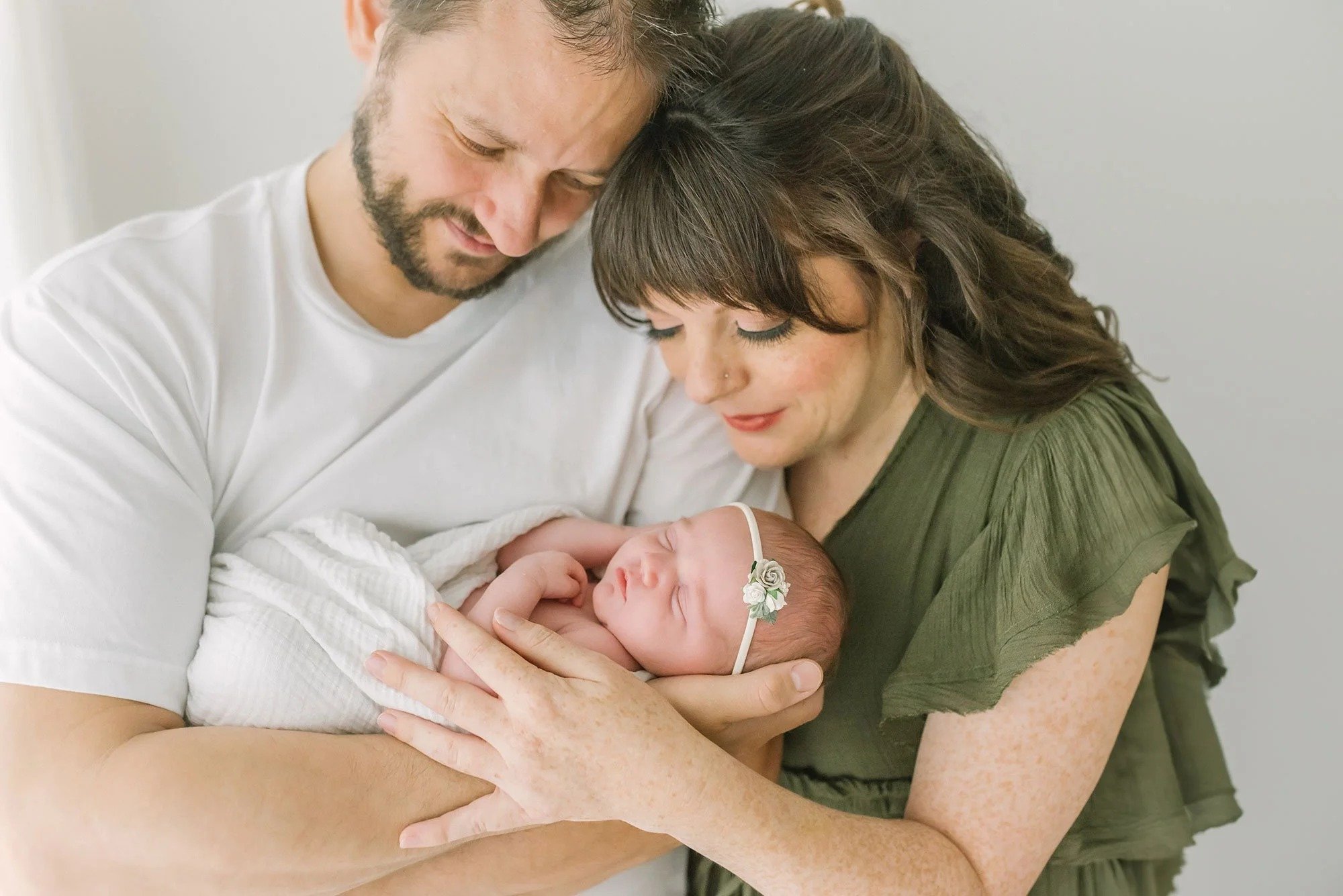 Parents looking at newborn baby in a newborn photography studio in Hamilton. 