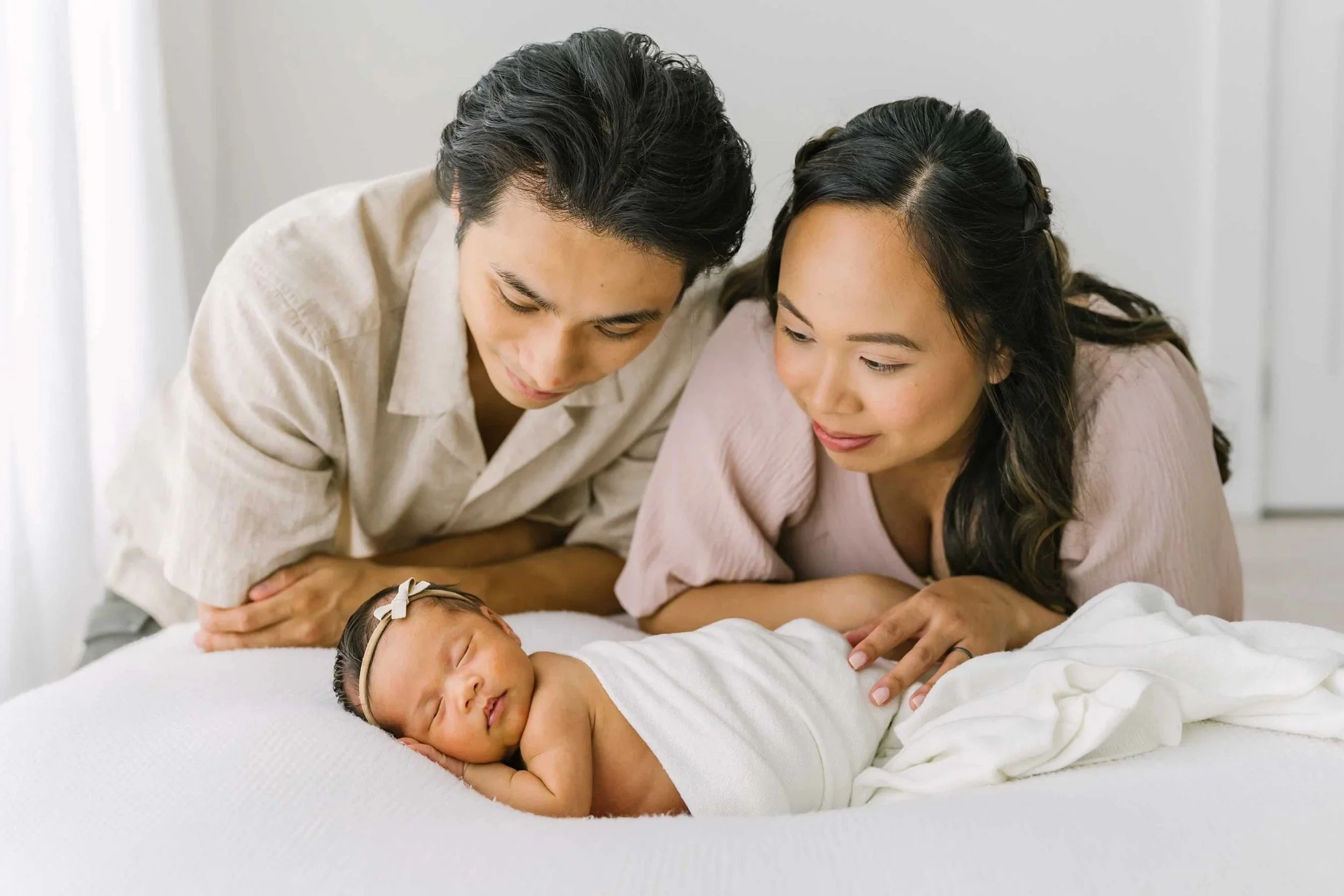 Parents looking at newborn at newborn photography studio near me
