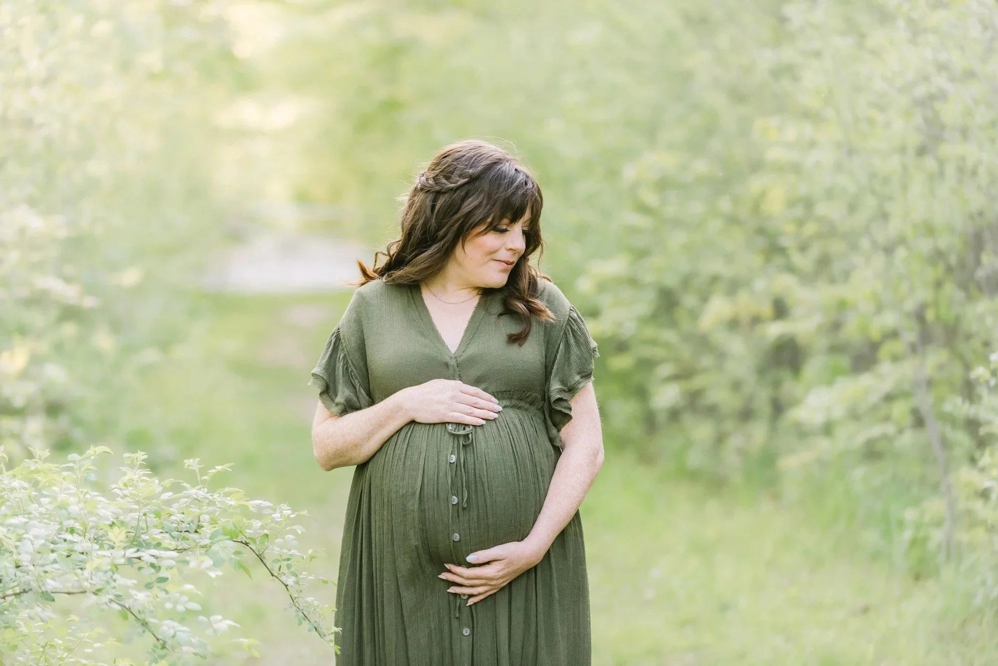 Pregnancy photos in a field and mom posing for maternity photography in the Niagara Region at Reflections studio
