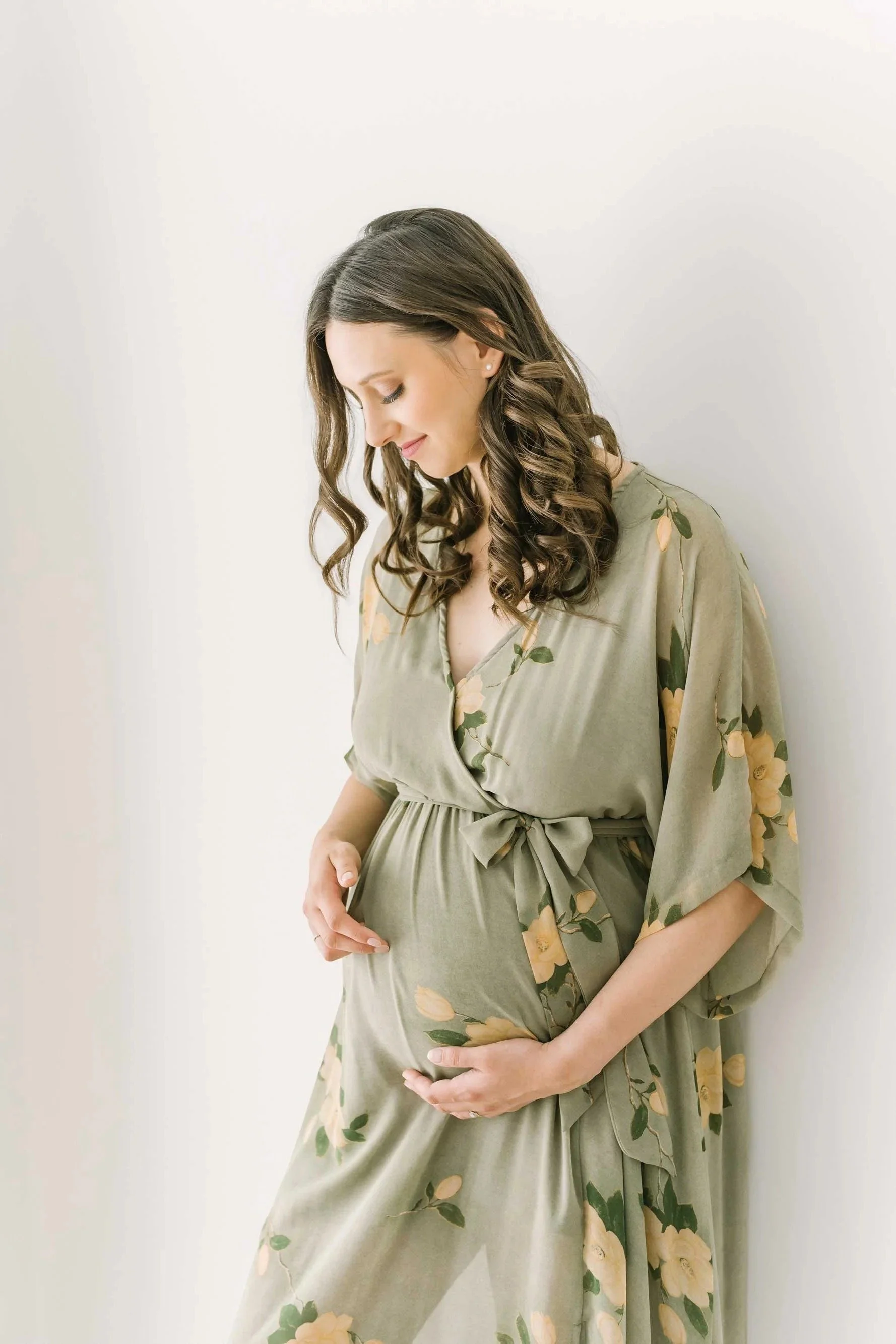 Mom leaning on a wall for Niagara Maternity Photography in the Reflections Photography studio