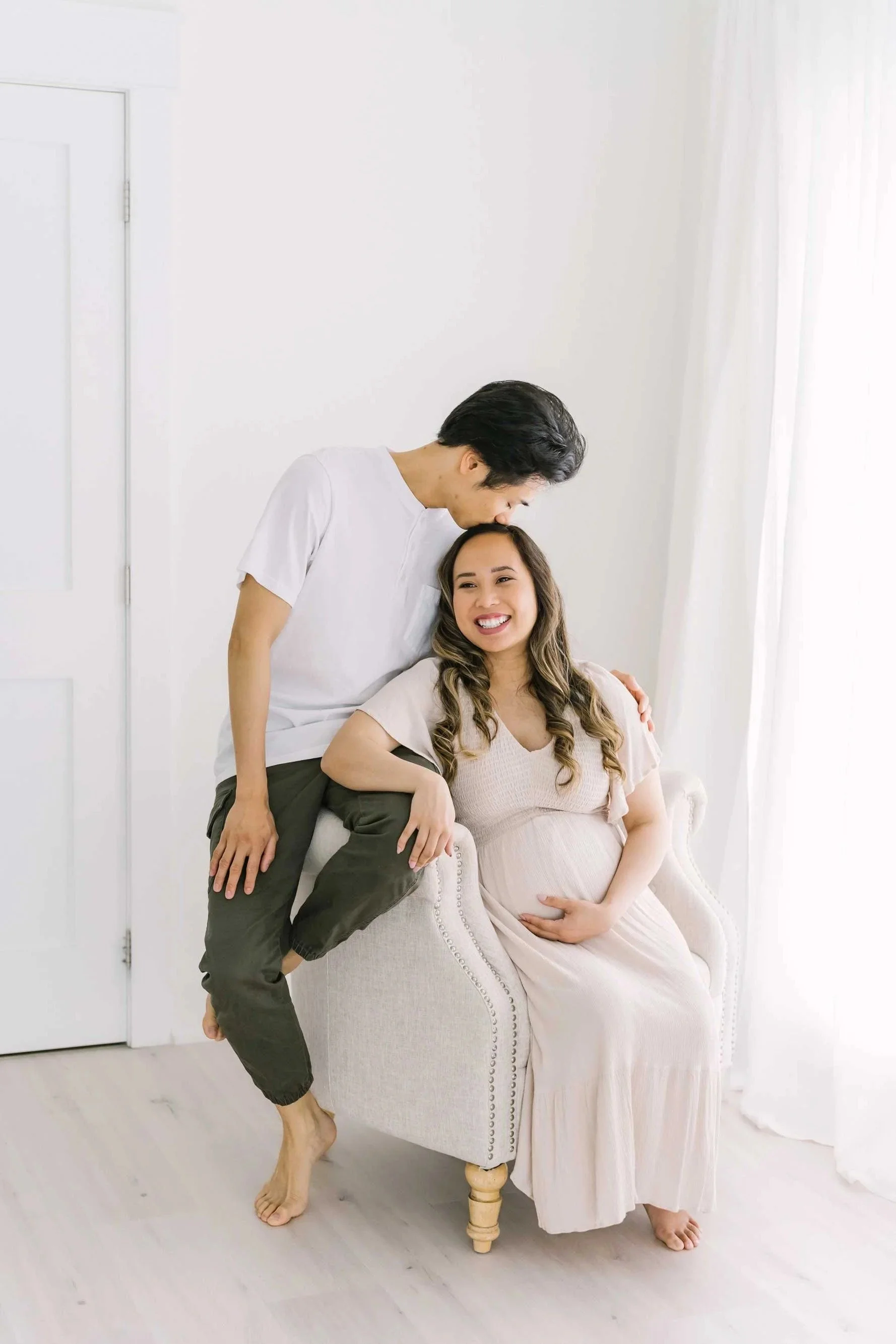 Mom and dad posing for pregnancy and maternity photography in Niagara at Reflections studio near me