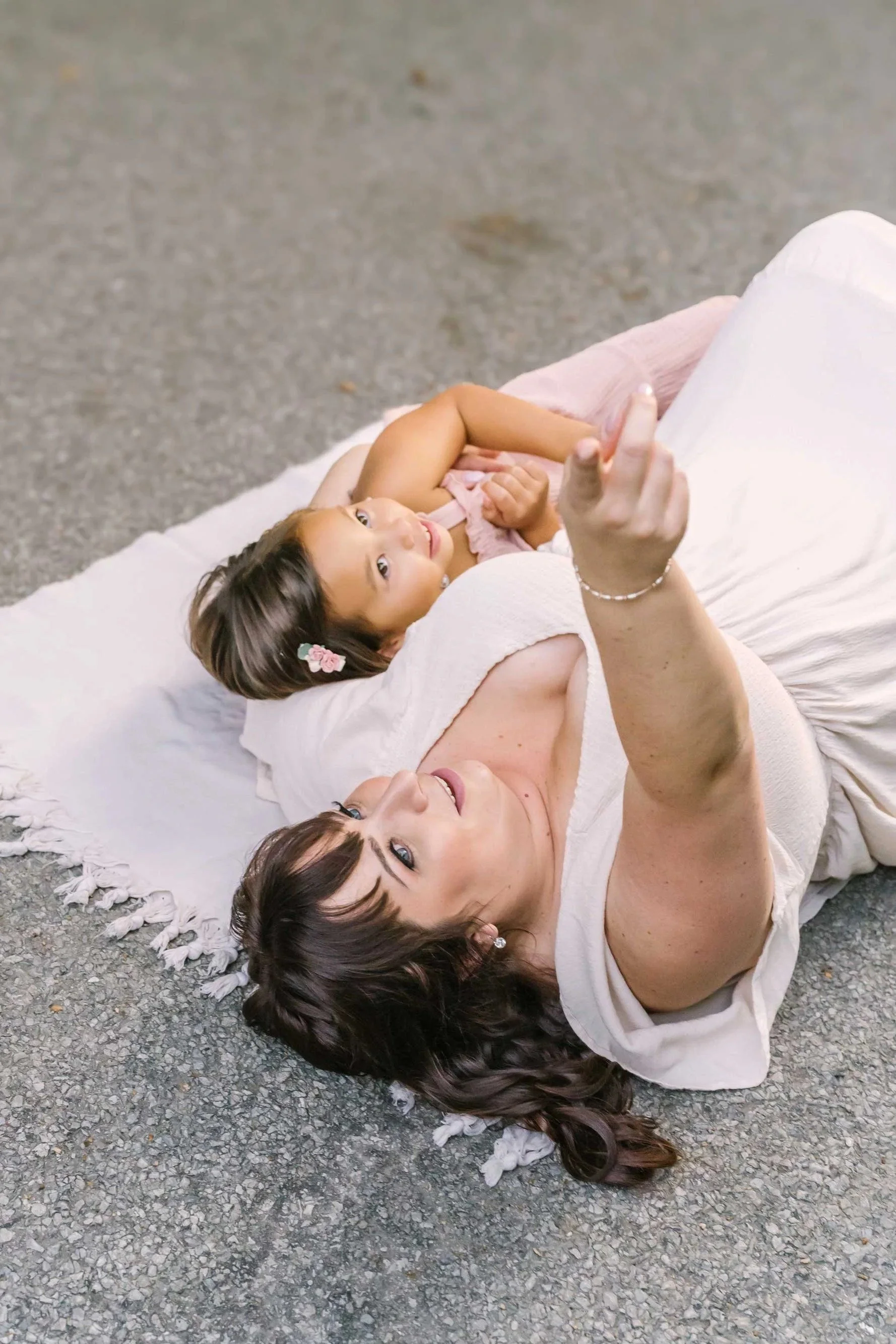 family photography in the niagara region by Reflections Photography of a mom and daughter laying on the ground