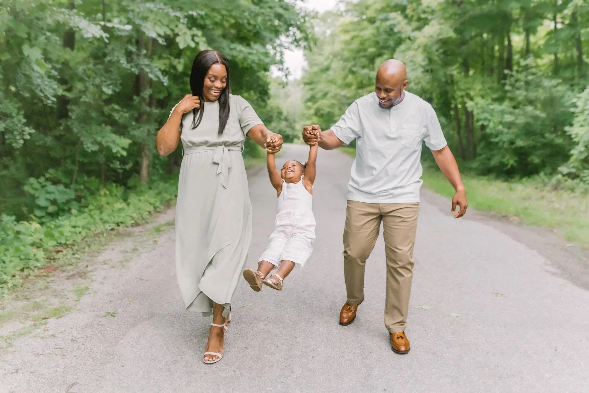 family photography in the niagara region by Reflections Photography of a family playing on a path in the woods