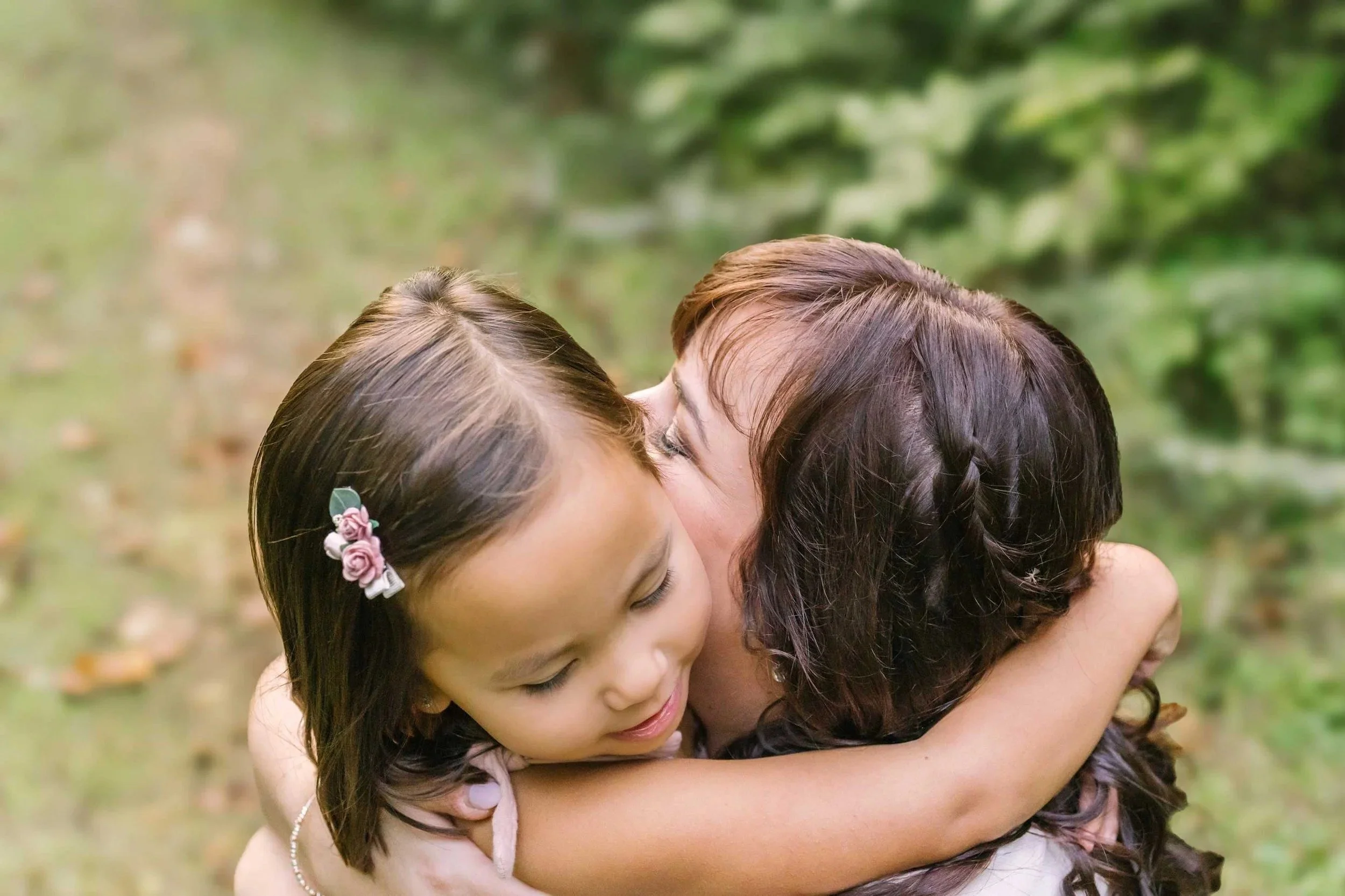 Family photography in the niagara region by Reflections Photography with mom kissing daughter
