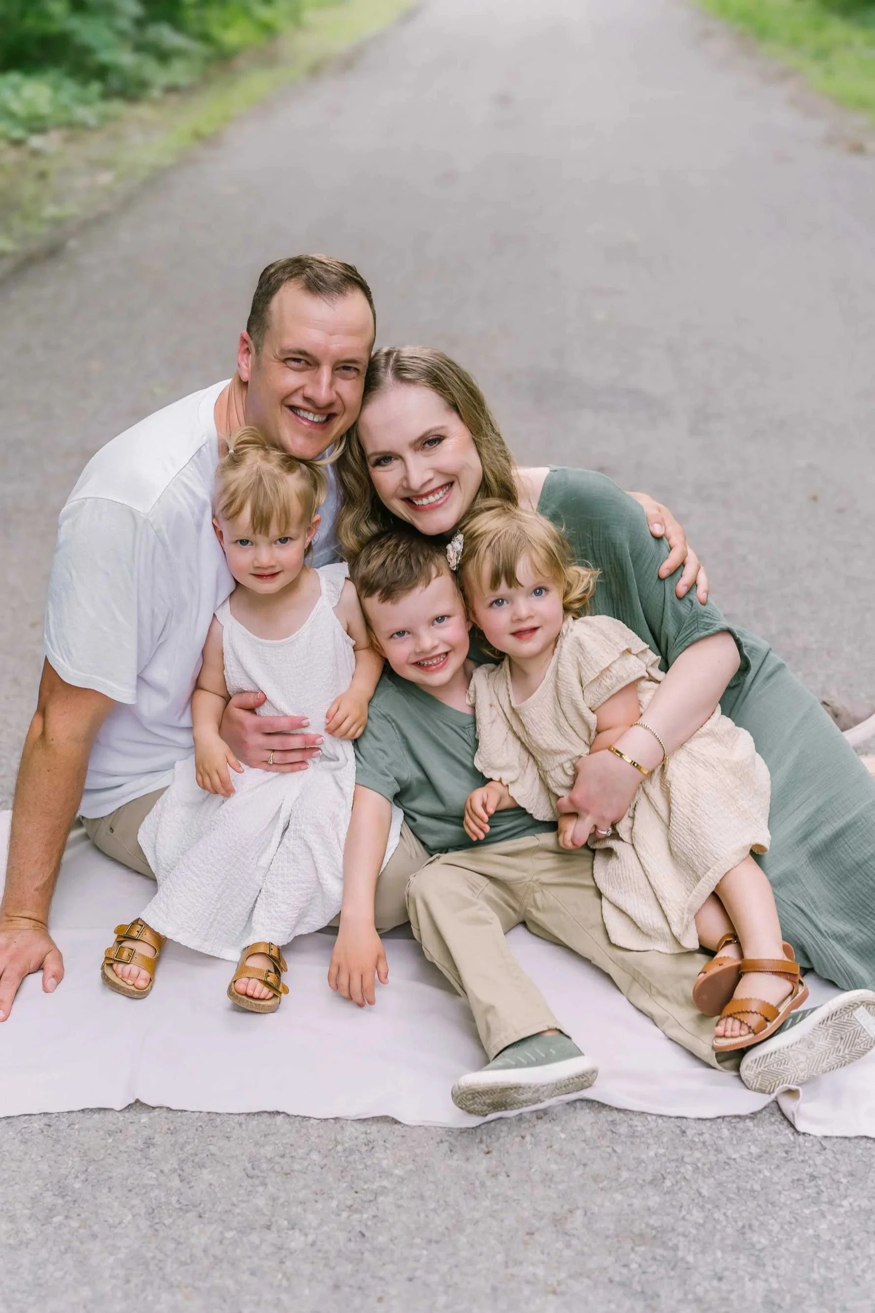 family photos in Niagara with a family sitting and snuggling on a path