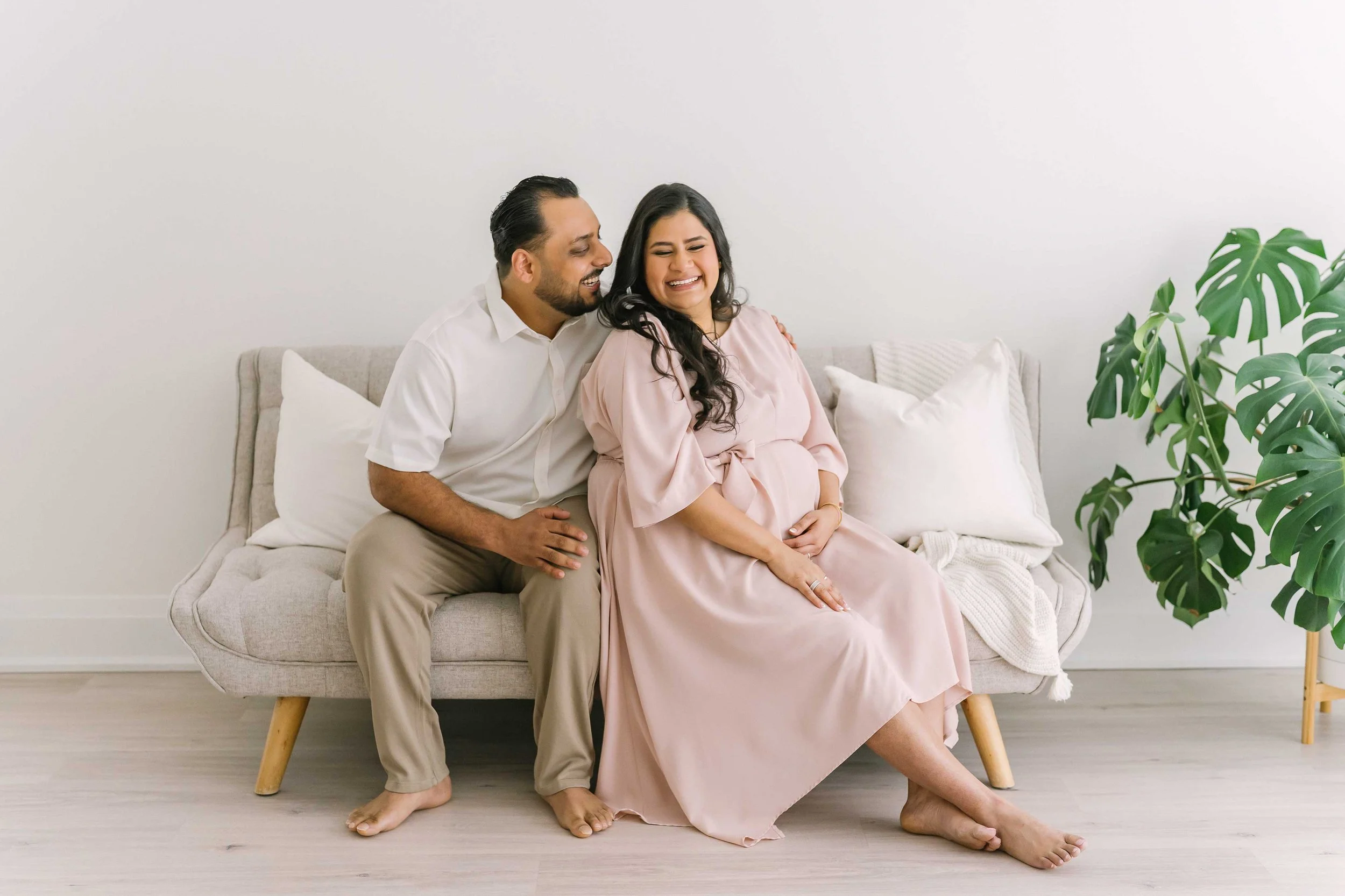 Expecting couple sharing a quiet moment together during a relaxed maternity photography session at a professional studio in Grimsby, Ontario.