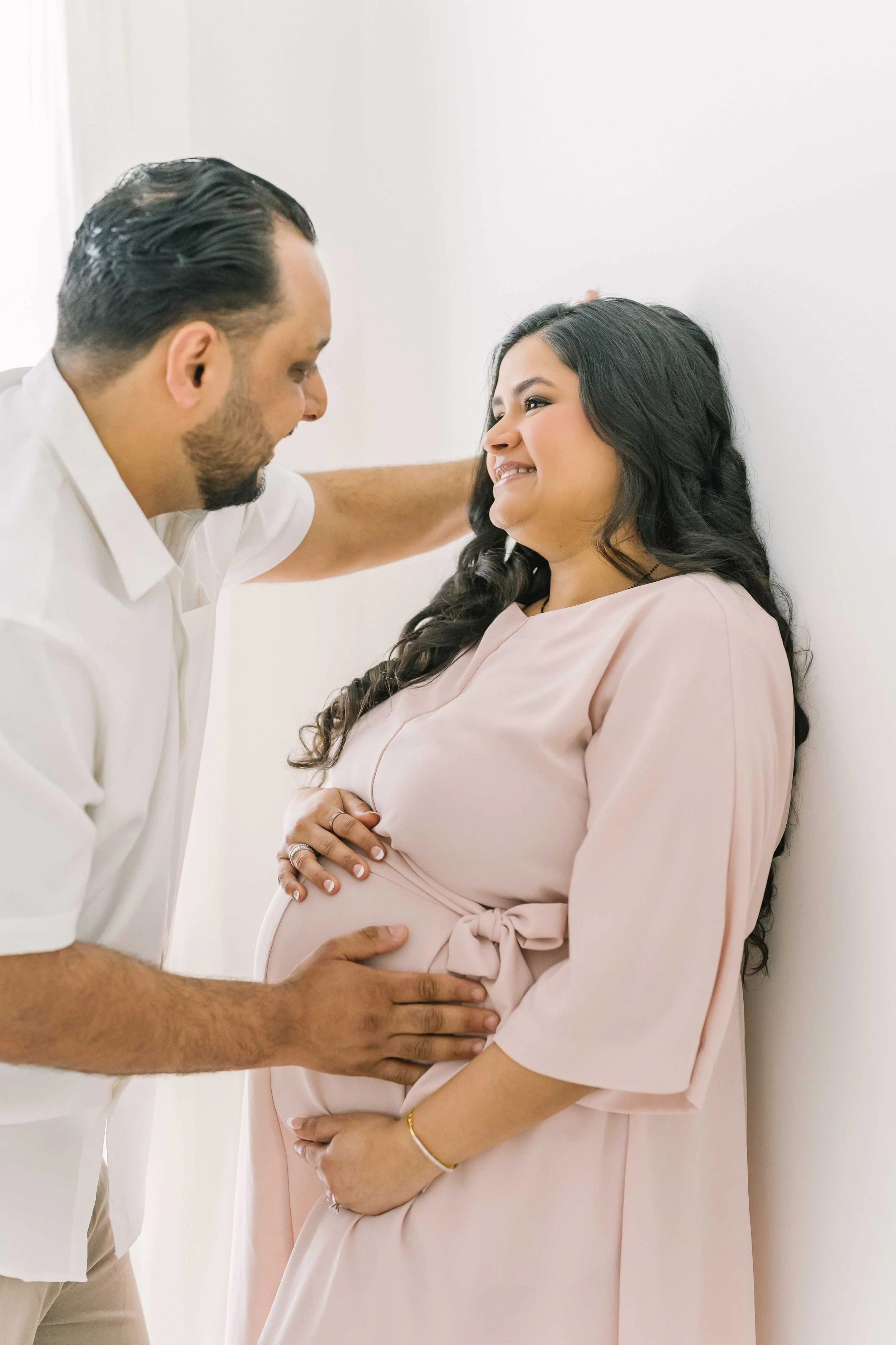 Beautiful pregnant mother smiling beside her partner during a natural and emotional maternity photoshoot in the Reflections Photography Grimsby studio.