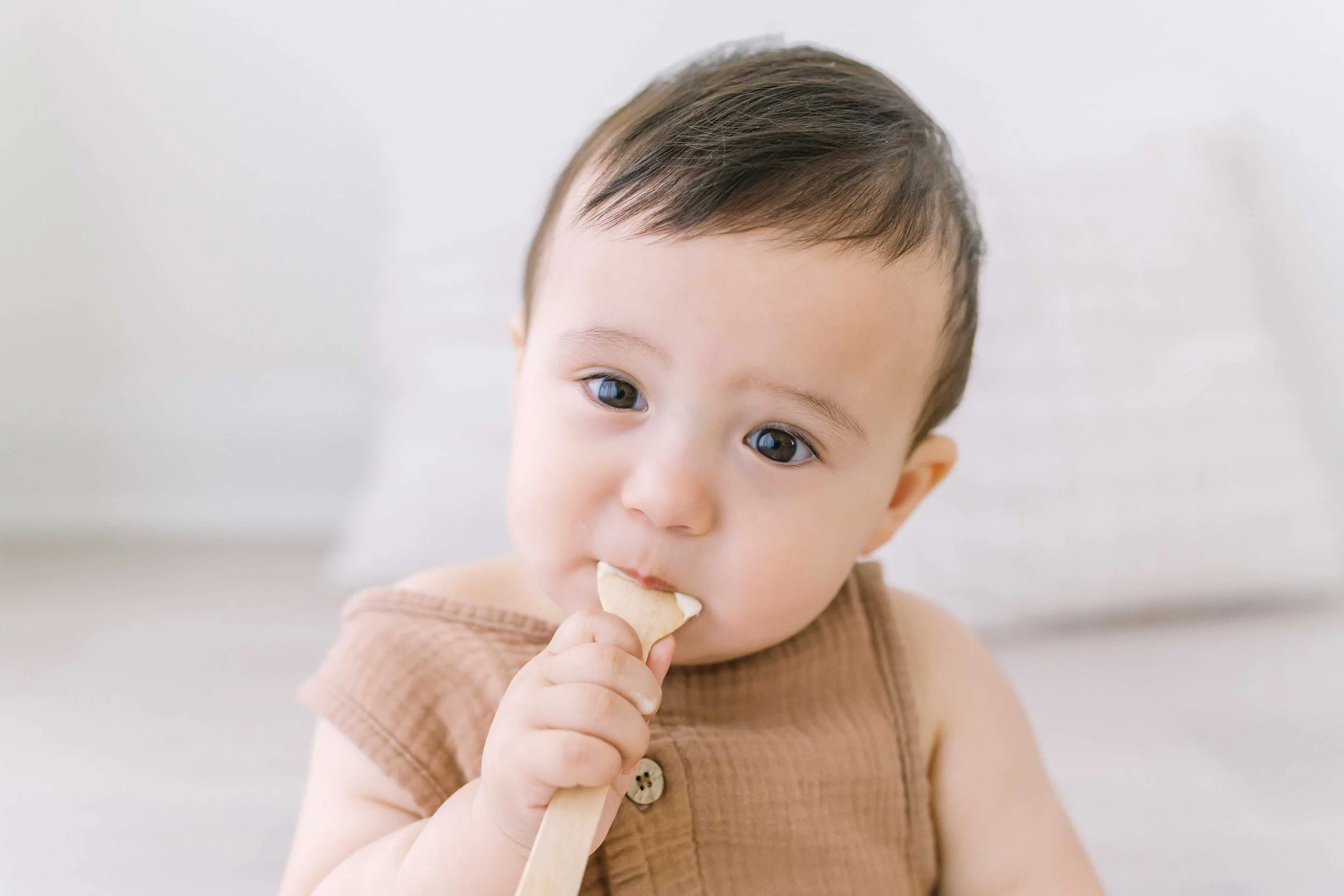 One-year milestone photography session showing a happy toddler exploring the studio space and smiling confidently at the camera.