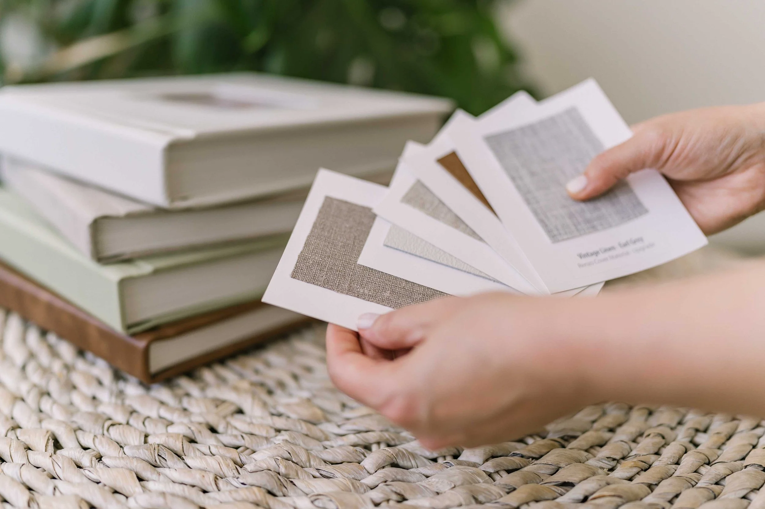 Parents flipping through custom heirloom photo albums Ontario with baby on couch