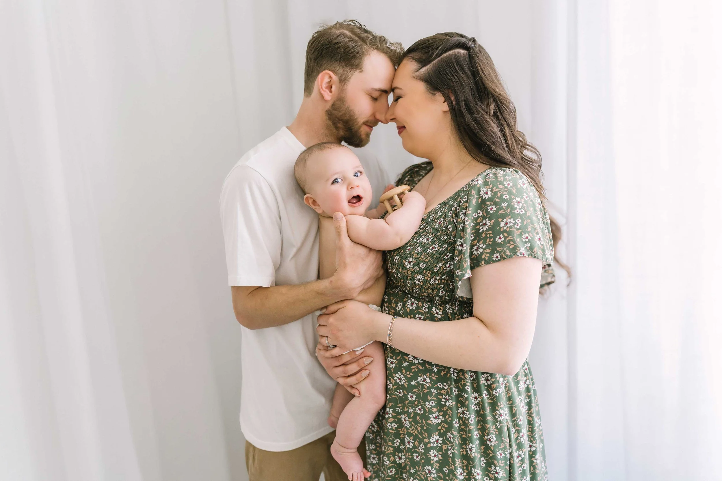 Baby girl smiling while cuddling with dad during Grimsby photography session