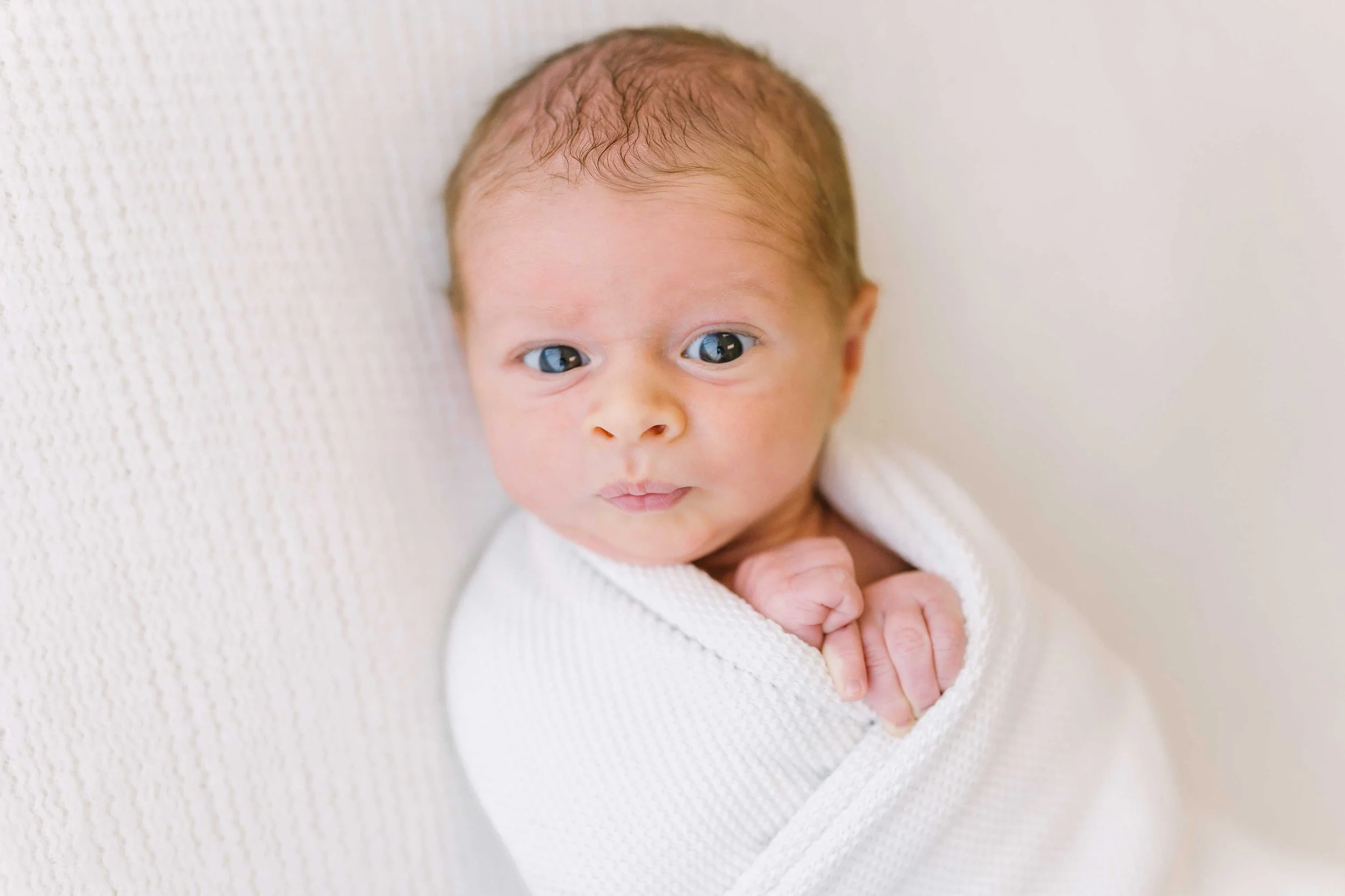 Close-up portrait of alert newborn baby with bright eyes at Grimsby photography studio
