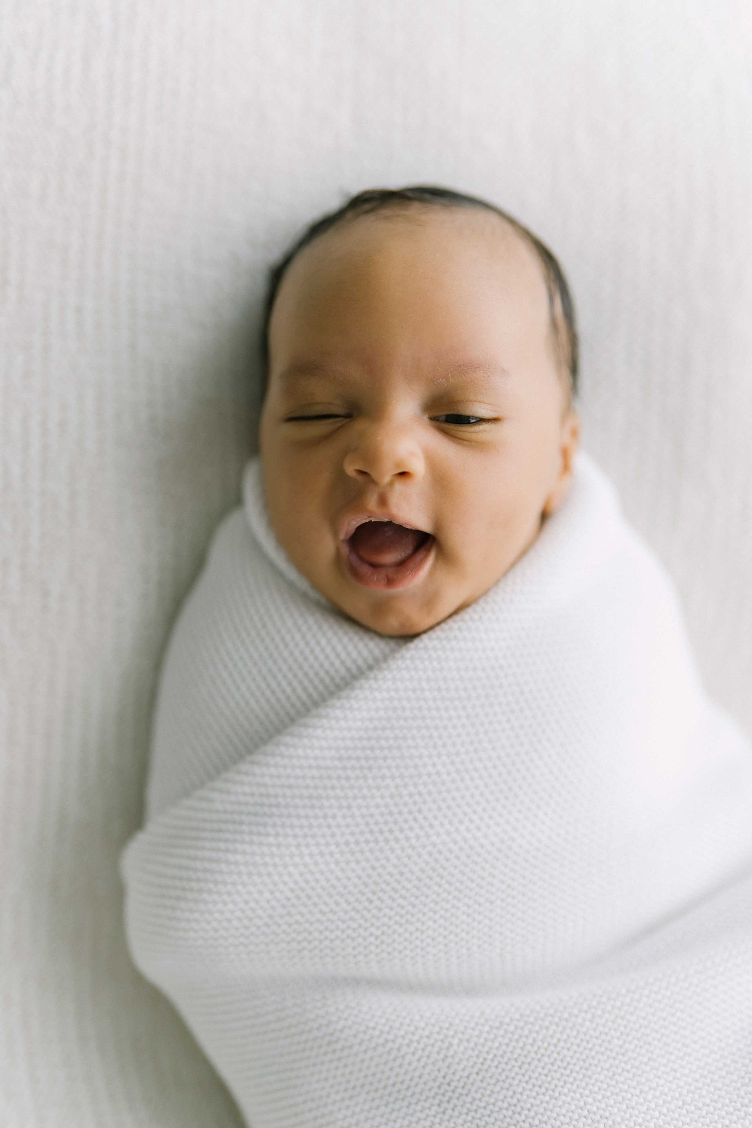 Newborn baby yawning during a newborn photography session in Grimsby