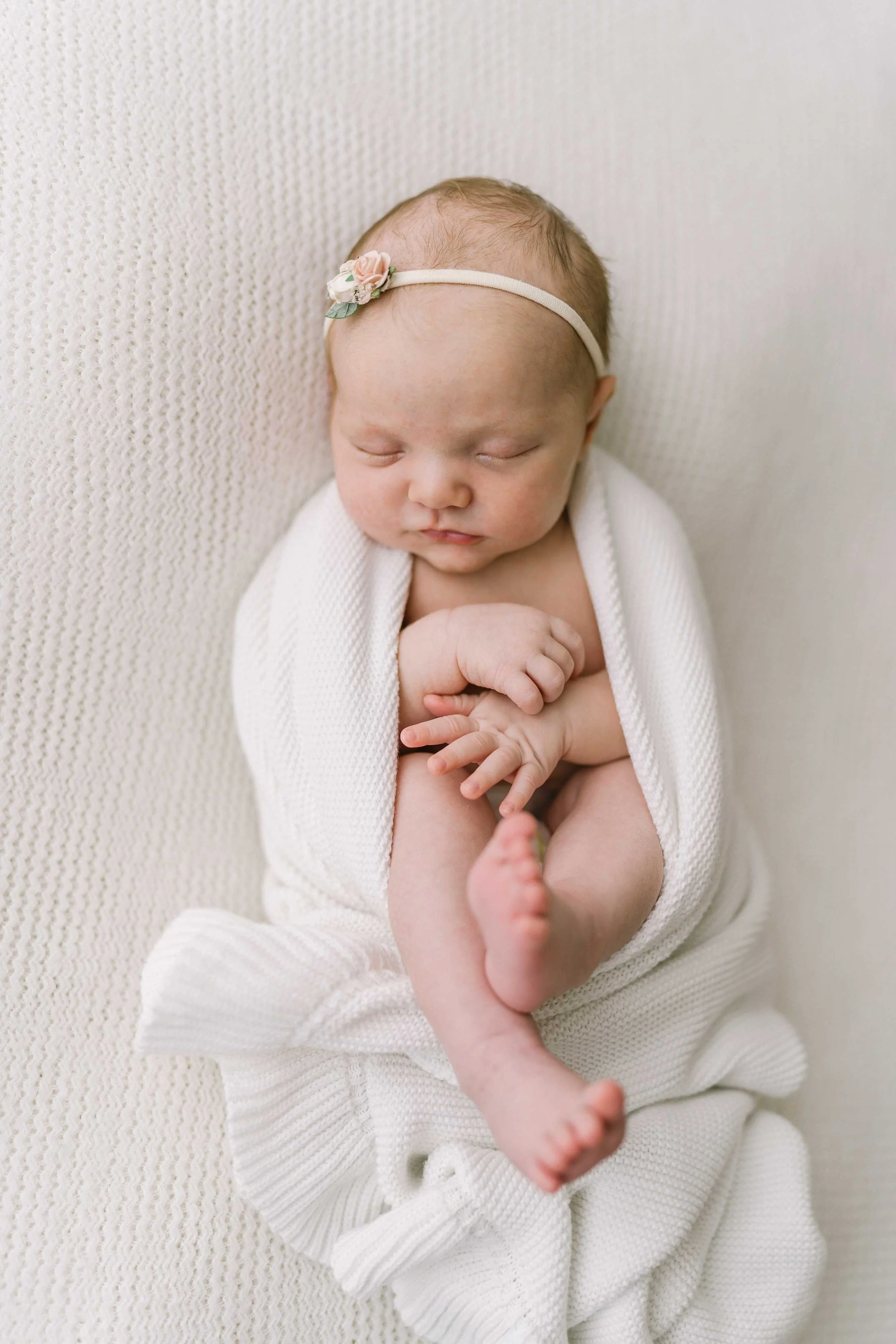 Newborn baby wrapped in a soft swaddle in Grimsby studio