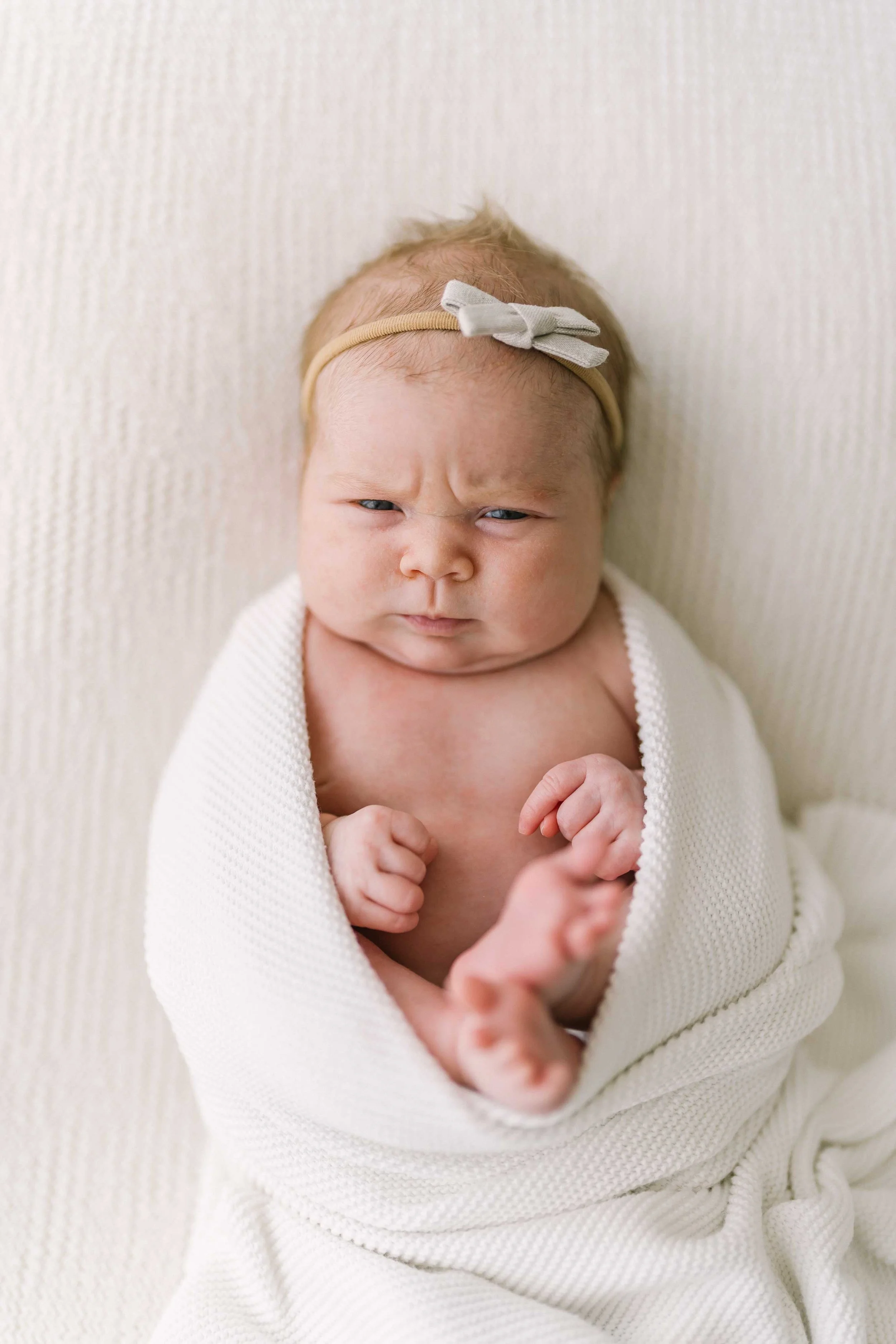 Awake newborn baby girl showing a serious expression during Grimsby newborn session
