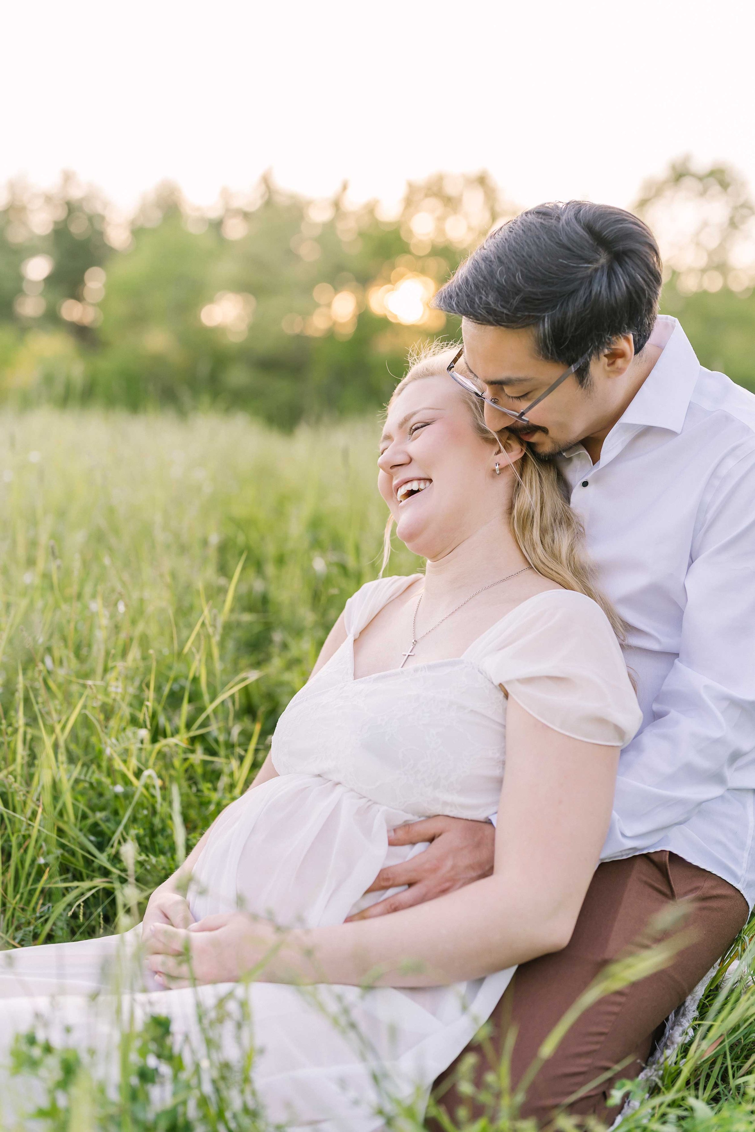 Expectant parents sharing a quiet moment in a Grimsby countryside field