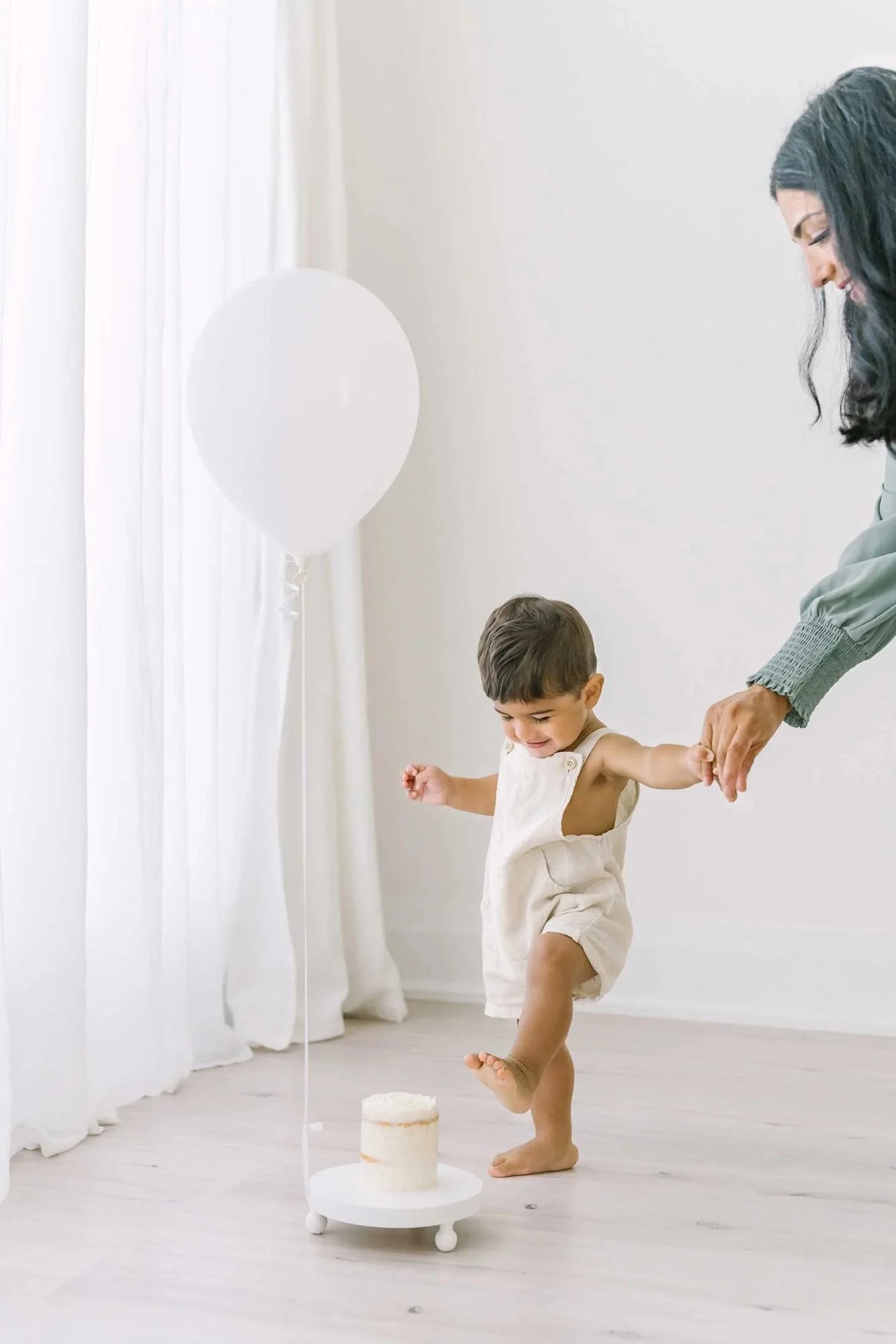 A one year old baby and cake, during a first year milestone moment in a child's life, celebrating a unique and memorable event taken by Niagara newborn photographer Karen Byker.