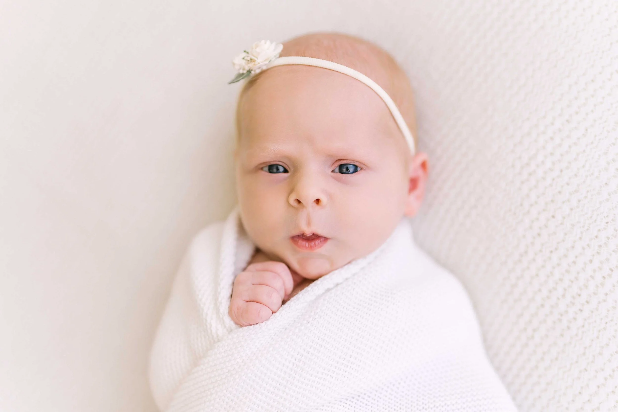 Lupia newborn baby girl showing her curious eyes during a studio session