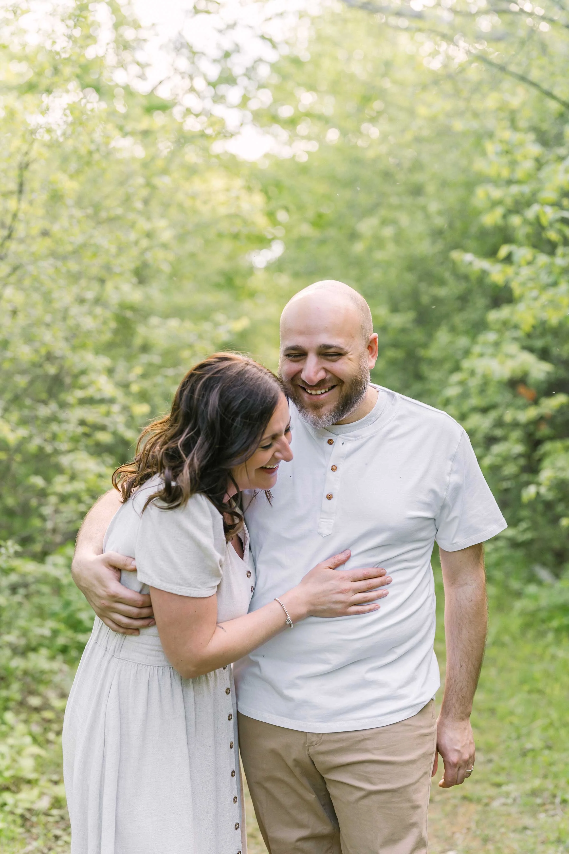 Parents sharing a quiet laughing moment during an outdoor family session in Niagara