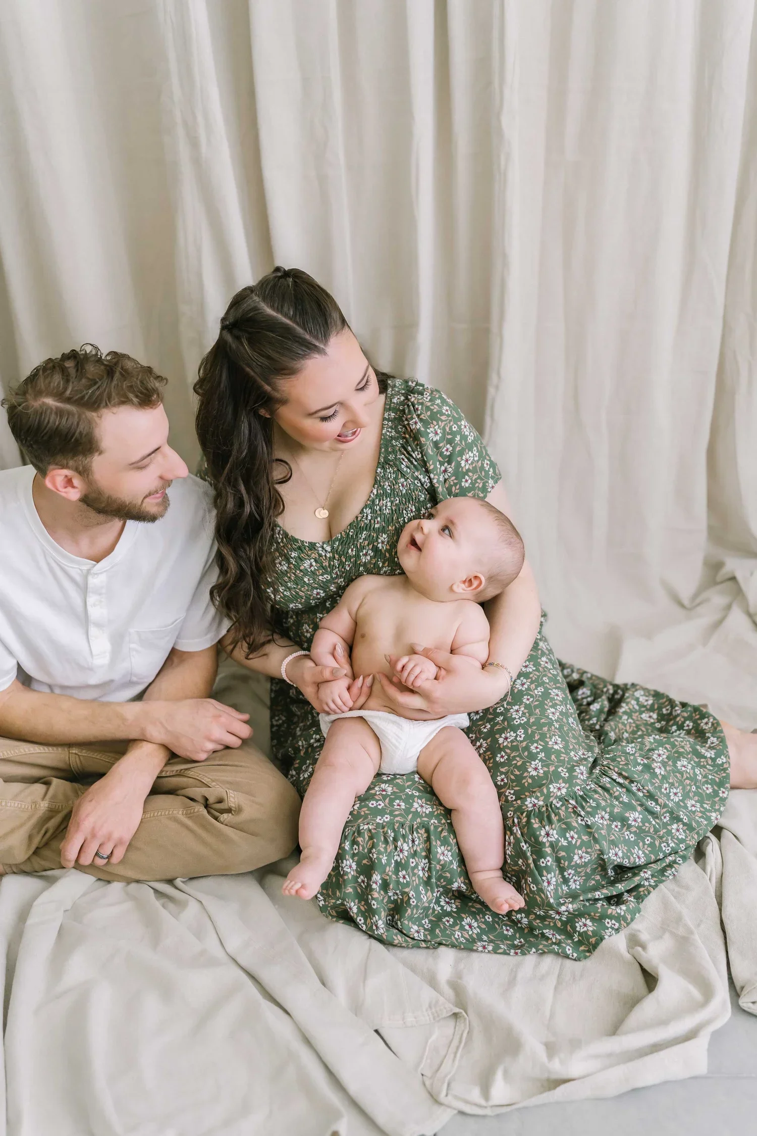 Parents looking at their baby for newborn photography in the Niagara region at Reflections studio in Grimsby