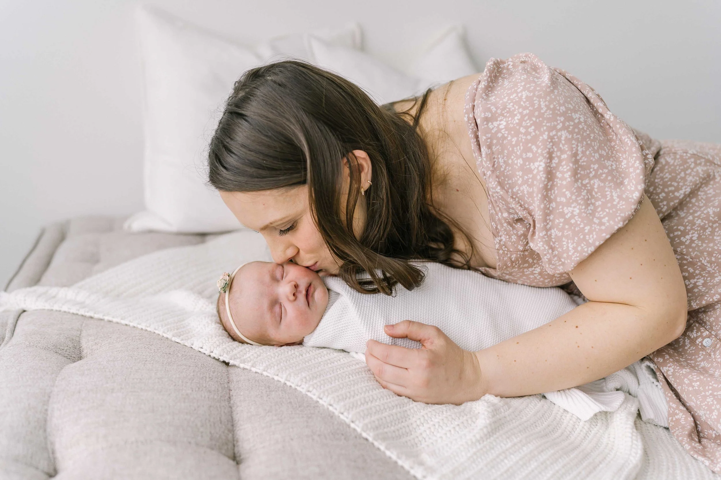 Mother holding newborn baby during a quiet studio session