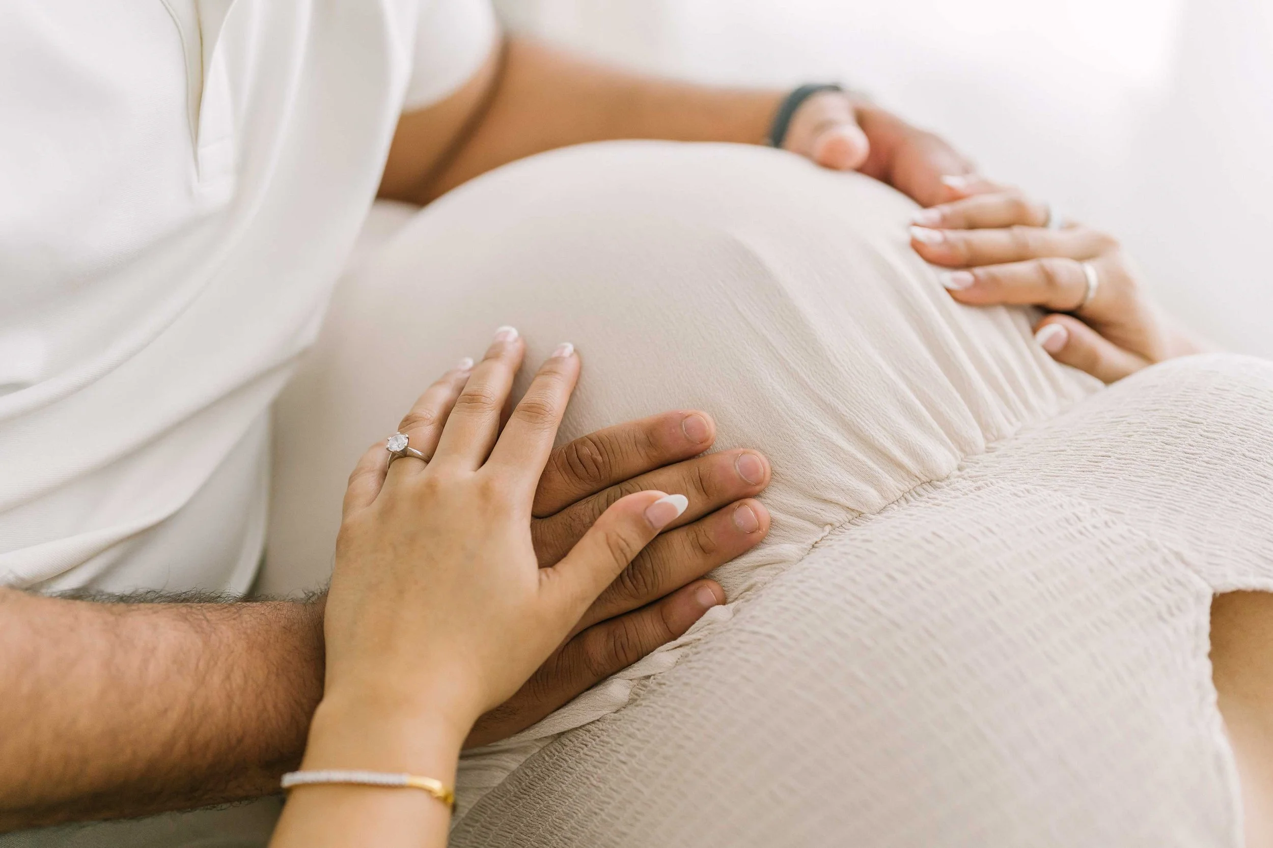 Detailed maternity photography image highlighting the connection between expecting parents and their unborn baby in a Grimsby studio session.
