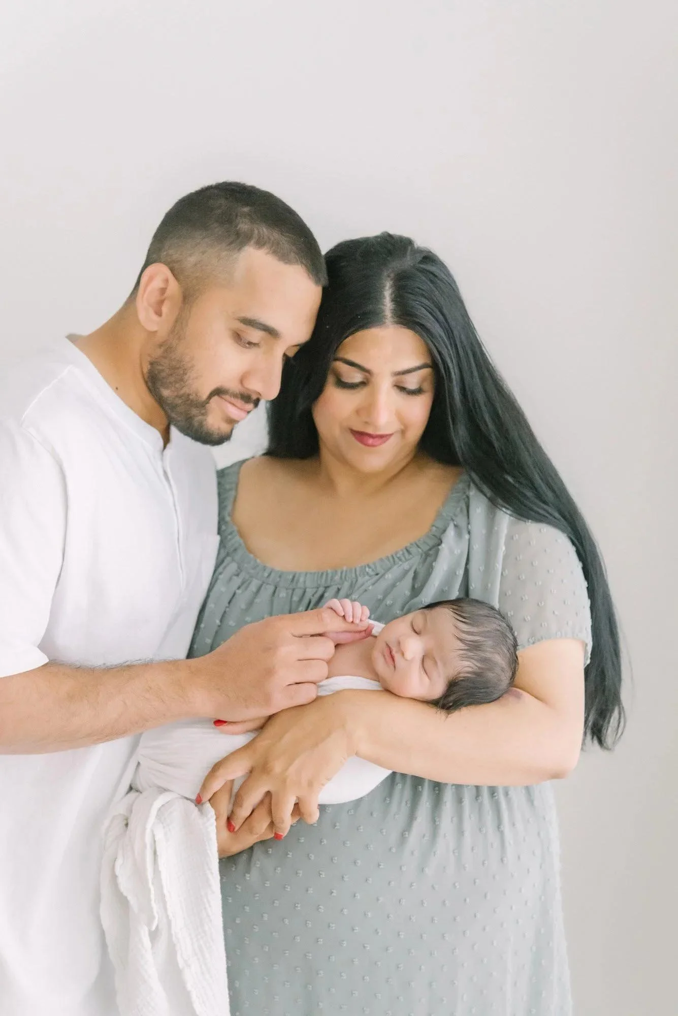 Couple holding newborn baby at their newborn photography session in Hamilton, Ontario