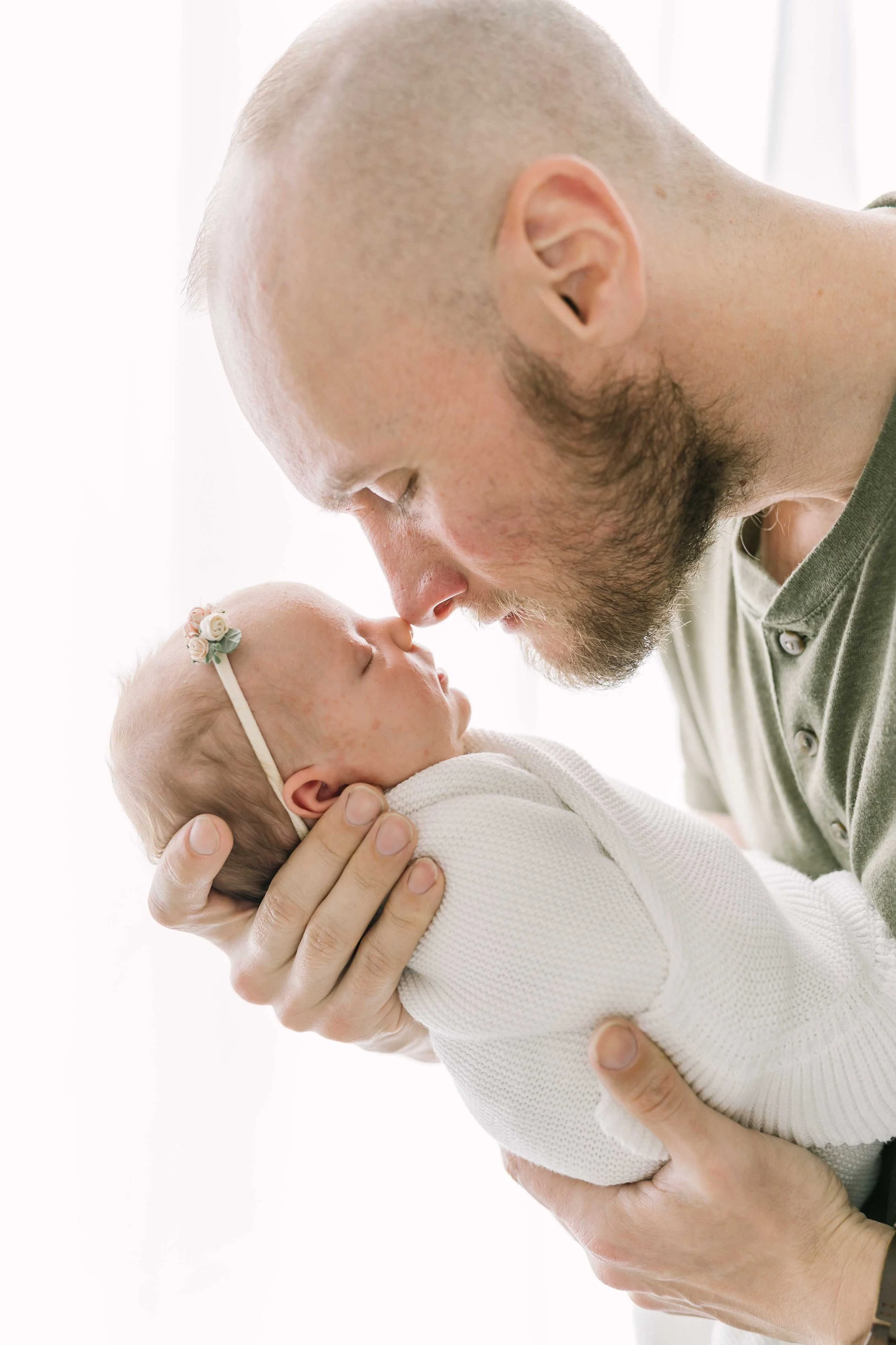 Father holding and looking at his newborn daughter